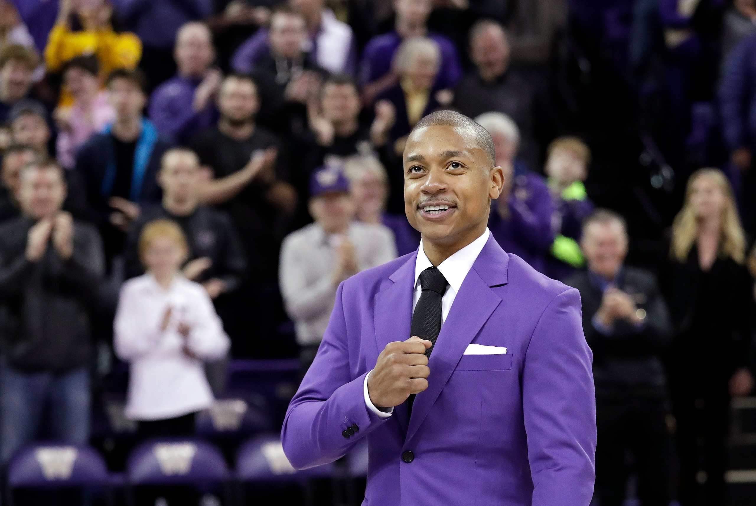 Former Washington guard Isaiah Thomas taps his fist to his heart as he is introduced during a ceremony retiring his jersey at halftime during an NCAA college basketball game against Colorado Saturday, Feb. 17, 2018, in Seattle. The Tacoma, Wash., native led the Huskies to three consecutive conference championships, and finished his three years with 1,721 career points, now eighth in all-time in scoring for men at the school. (AP Photo/Elaine Thompson)