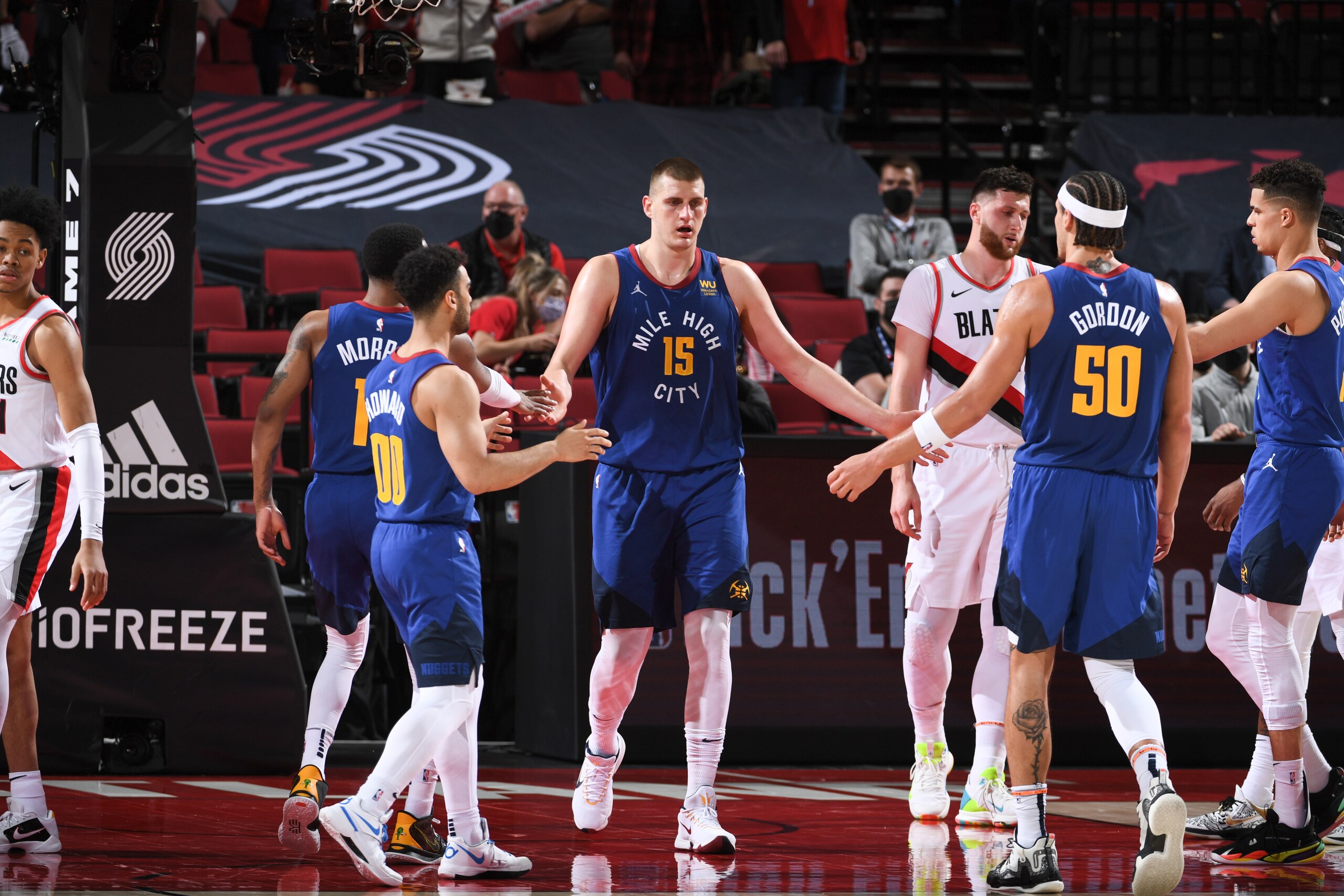 PORTLAND, OR - May 27: Nikola Jokic #15 of the Denver Nuggets high fives Monte Morris #11 of the Denver Nuggets and Aaron Gordon #50 of the Denver Nuggets during the game against the Portland Trail Blazers during Round 1, Game 3 of the 2021 NBA Playoffs on May 27, 2021 at the Moda Center Arena in Portland, Oregon. NOTE TO USER: User expressly acknowledges and agrees that, by downloading and/or using this Photograph, user is consenting to the terms and conditions of the Getty Images License Agreement. Mandatory Copyright Notice: Copyright 2021 NBAE (Photo by Garrett Ellwood/NBAE via Getty Images)