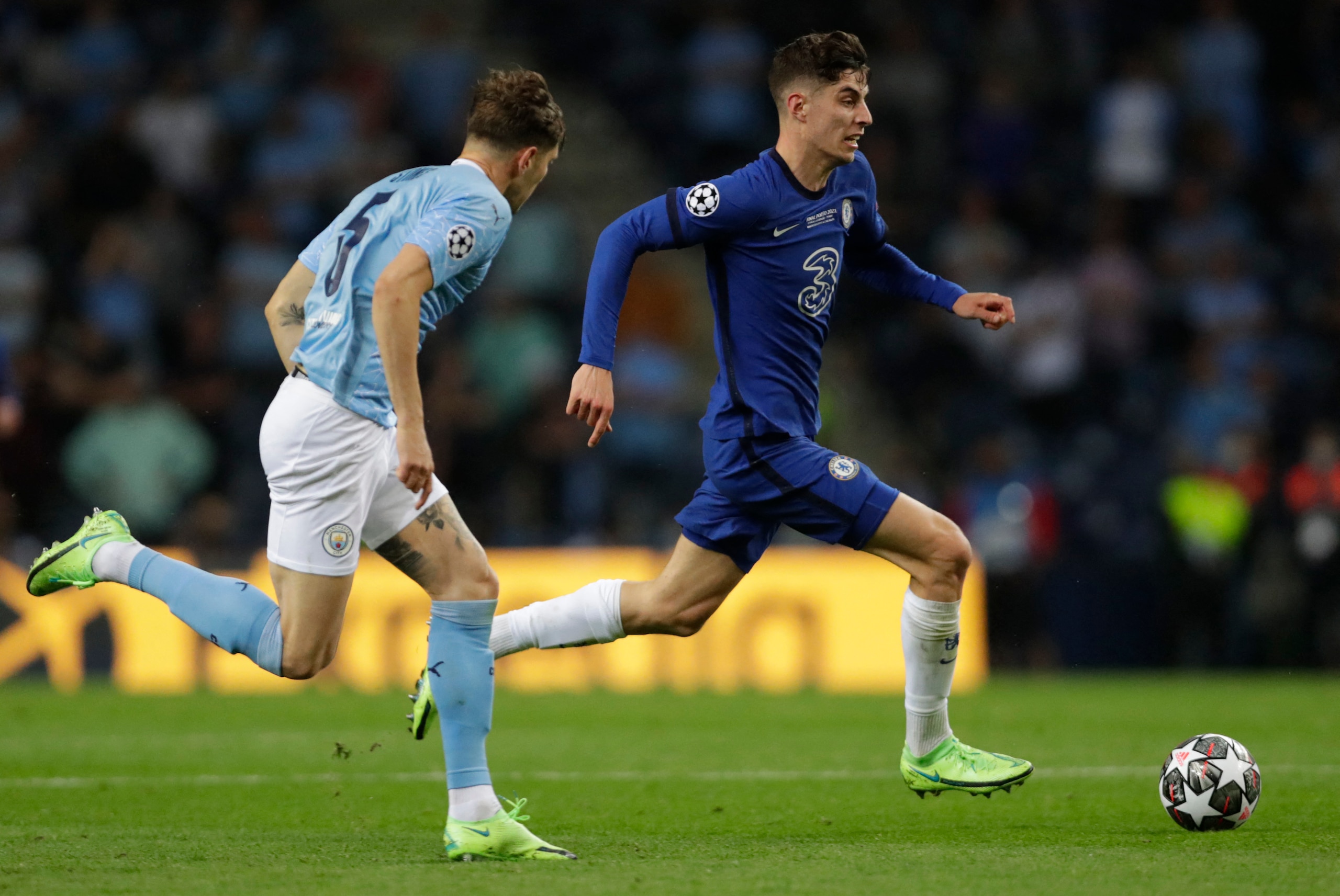 Chelsea's American midfielder Christian Pulisic (R) runs with the ball as Manchester City's English defender John Stones (L) chases him during the UEFA Champions League final football match between Manchester City and Chelsea at the Dragao stadium in Porto on May 29, 2021. (Photo by Manu Fernandez / POOL / AFP) (Photo by MANU FERNANDEZ/POOL/AFP via Getty Images)