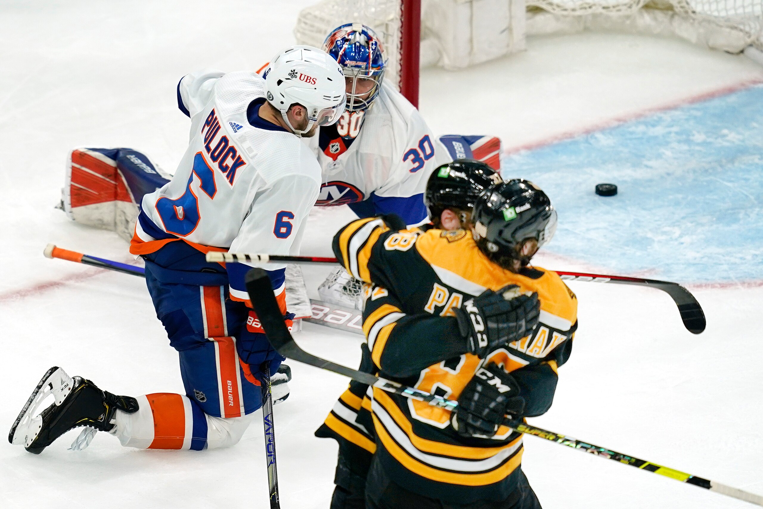 New York Islanders goaltender Ilya Sorokin (30) and defenseman Ryan Pulock (6) react as Boston Bruins right wing David Pastrnak (88) celebrates his goal with center Patrice Bergeron (37) in the second period of Game 1 during an NHL hockey second-round playoff series, Saturday, May 29, 2021, in Boston. (AP Photo/Elise Amendola)