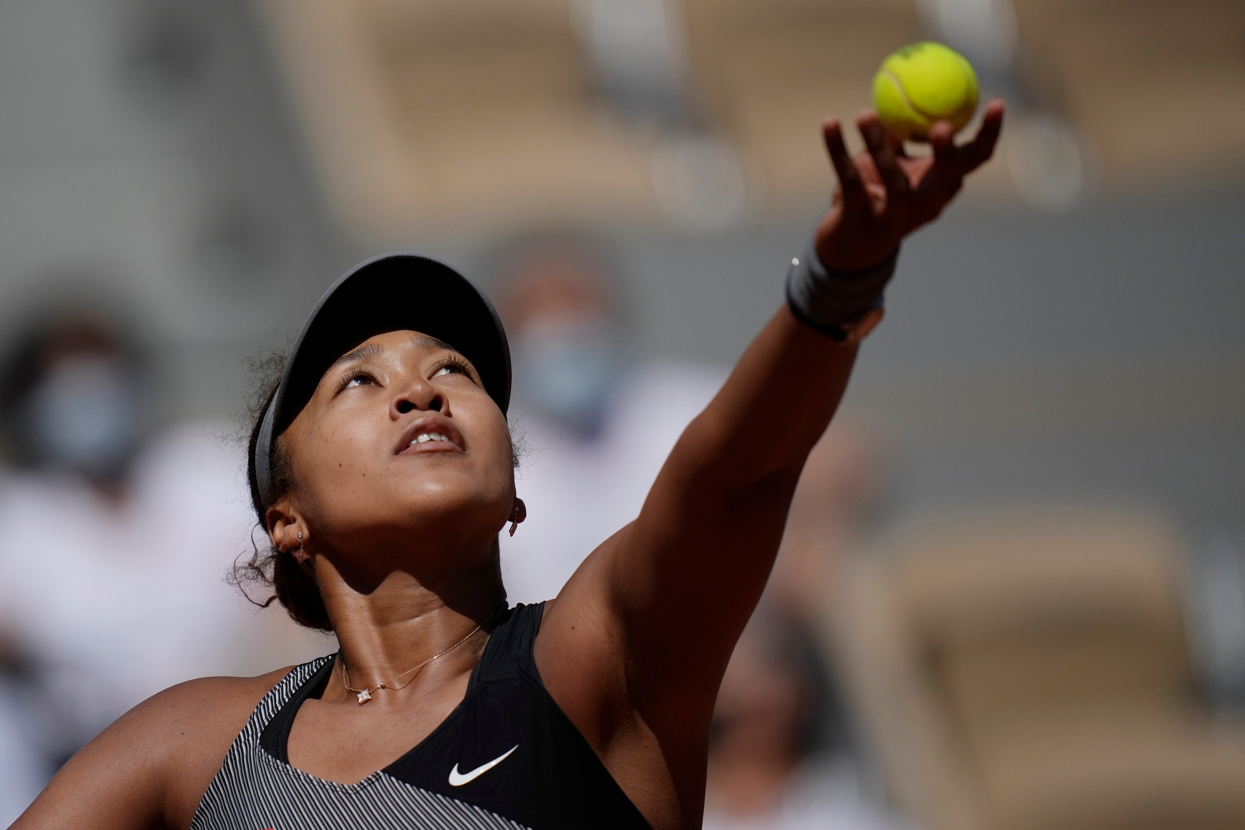 Japan's Naomi Osaka serves the ball to Romania's Patricia Maria Tig during their first round match of the French open tennis tournament at the Roland Garros stadium Sunday, May 30, 2021 in Paris. (AP Photo/Christophe Ena)