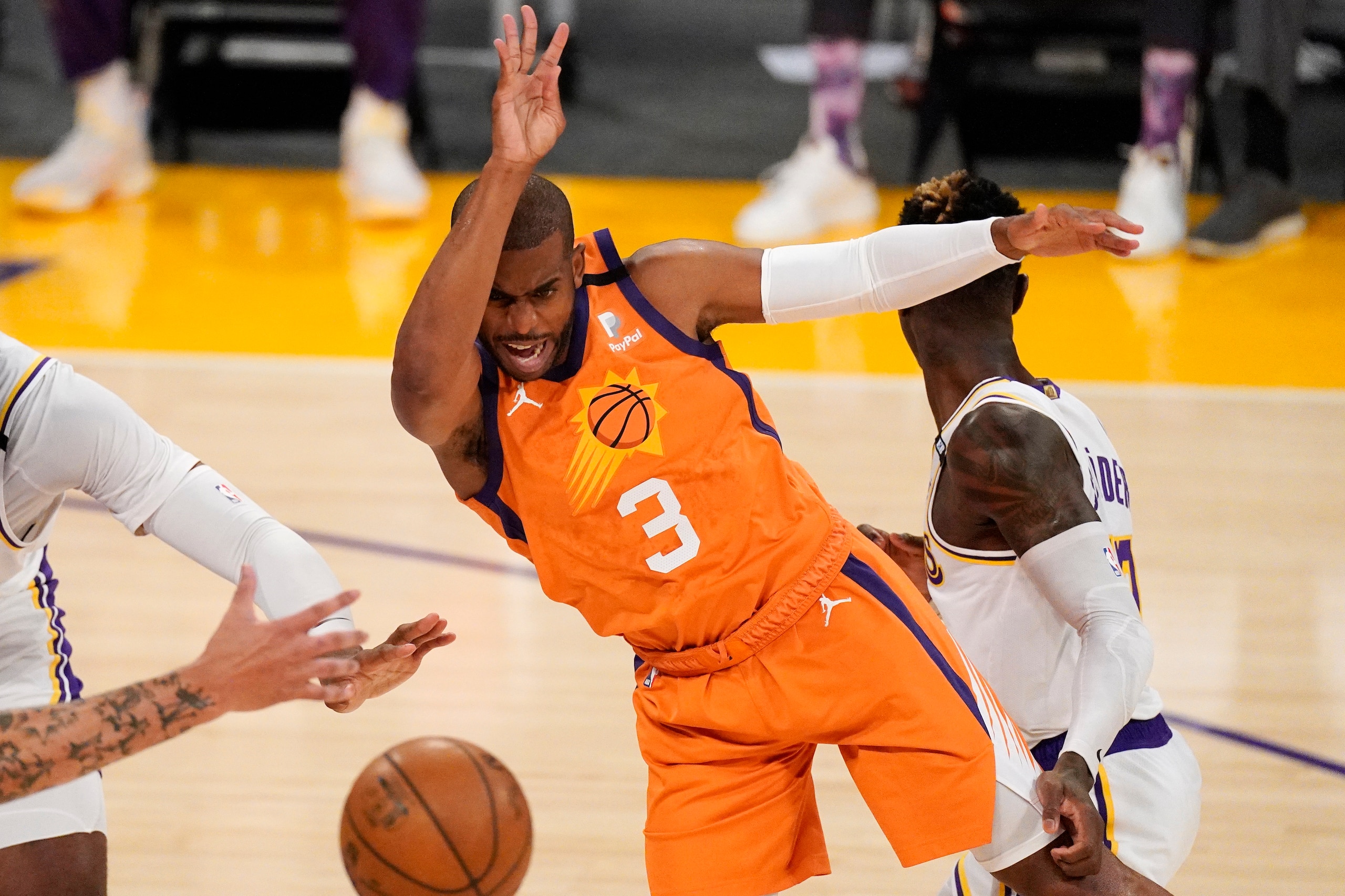 Phoenix Suns guard Chris Paul, left, passes the ball while under pressure from Los Angeles Lakers guard Dennis Schroder, right, during the first half in Game 4 of an NBA basketball first-round playoff series Sunday, May 30, 2021, in Los Angeles. (AP Photo/Mark J. Terrill)
