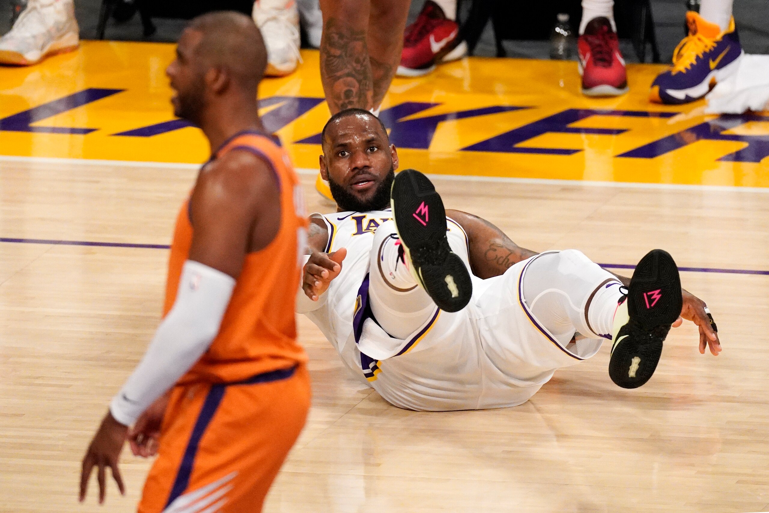 Los Angeles Lakers forward LeBron James, right, falls after being fouled as Phoenix Suns guard Chris Paul stands at left during the second half in Game 4 of an NBA basketball first-round playoff series Sunday, May 30, 2021, in Los Angeles. (AP Photo/Mark J. Terrill)