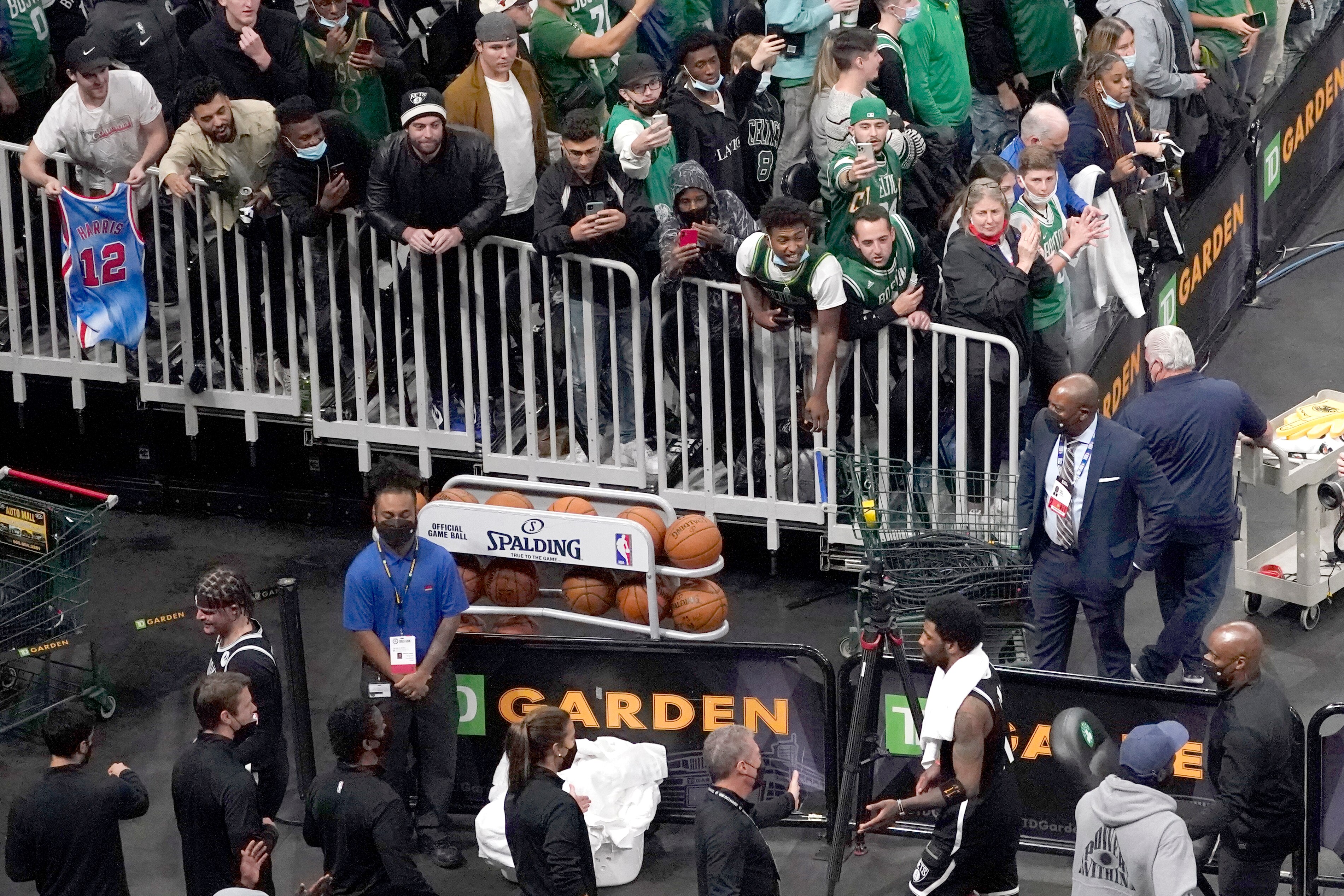 Brooklyn Nets guard Kyrie Irving, below right with towel, leaves the court as TD Garden fans engage with him after they defeated the Boston Celtics 141-126 in Game 4 during an NBA basketball first-round playoff series, Sunday, May 30, 2021, in Boston. (AP Photo/Elise Amendola)