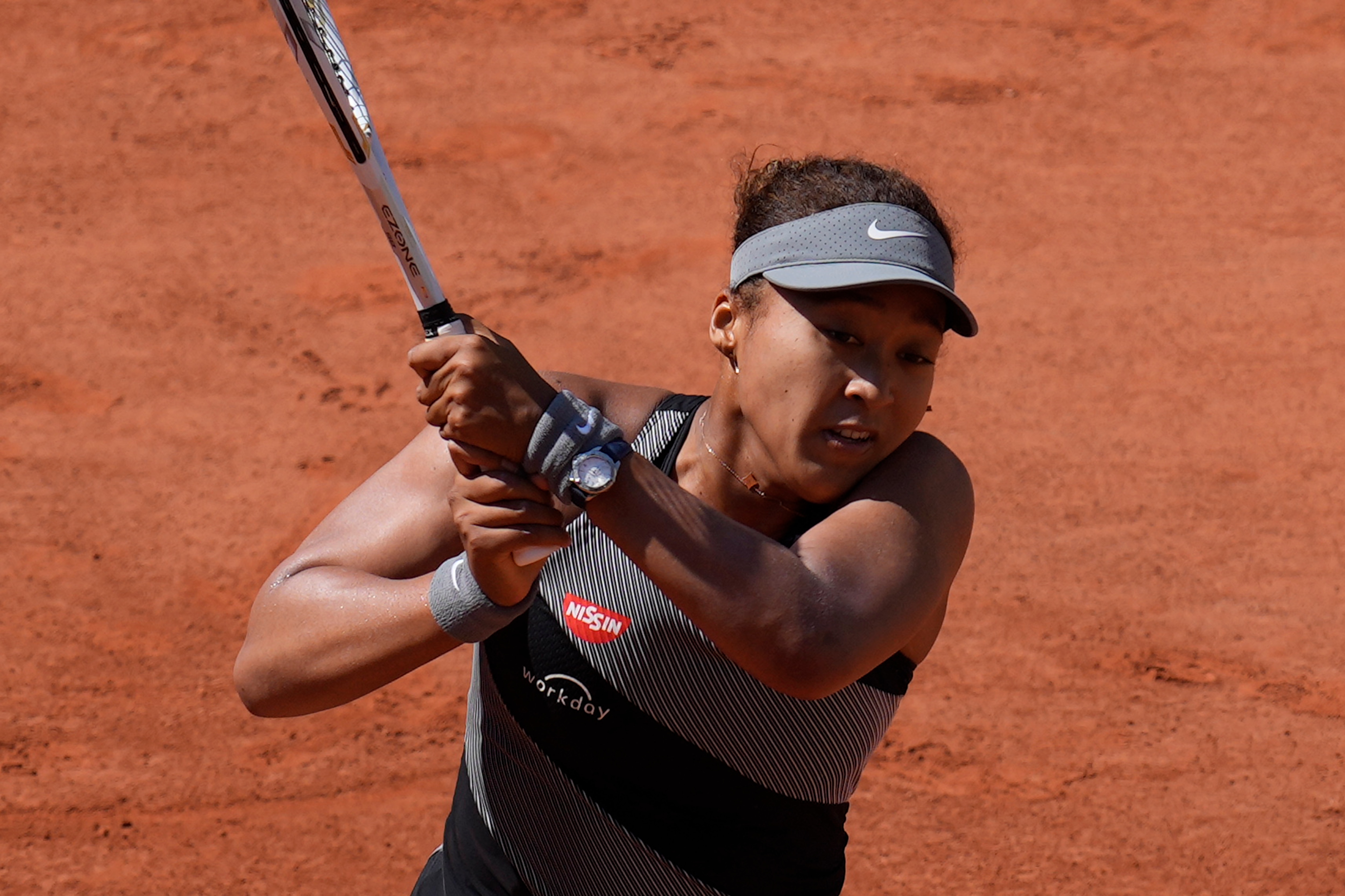 Japan's Naomi Osaka returns the ball to Romania's Patricia Maria Tig during their first round match of the French open tennis tournament at the Roland Garros stadium Sunday, May 30, 2021 in Paris. (AP Photo/Christophe Ena)