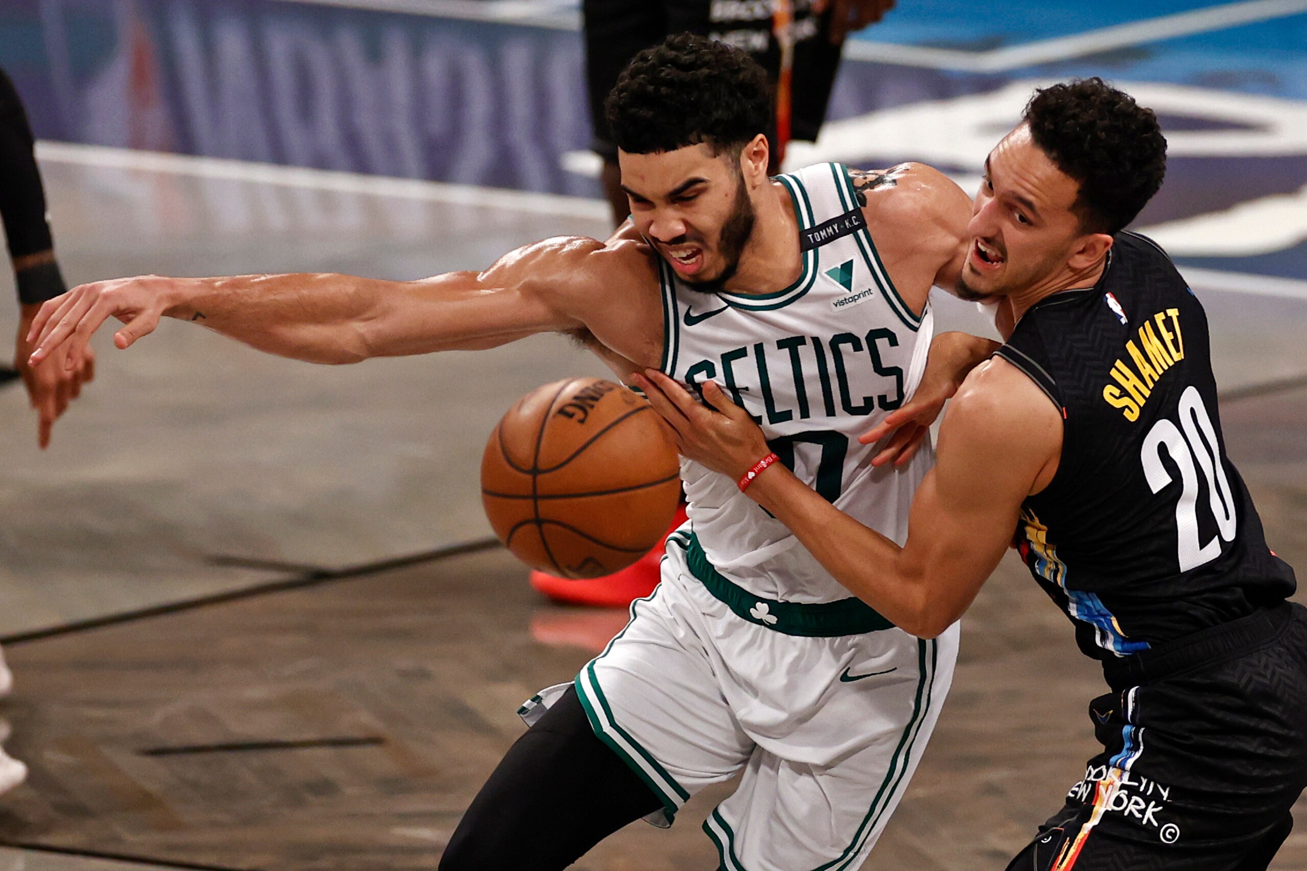 Boston Celtics forward Jayson Tatum, left, and Brooklyn Nets guard Landry Shamet, right,  battle for a loose ball in the second half of Game 5 during an NBA basketball first-round playoff series, Tuesday, June 1, 2021, in New York. (AP Photo/Adam Hunger)