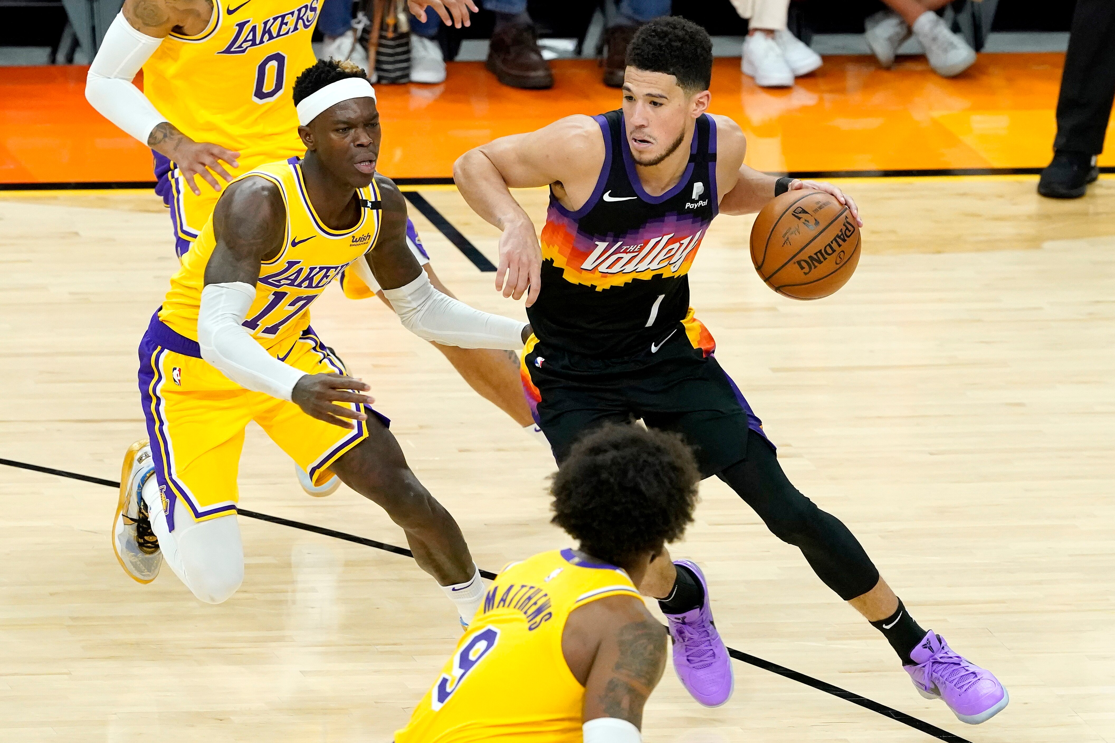 Phoenix Suns guard Devin Booker (1) drives as Los Angeles Lakers guard Dennis Schroder (17) defends during the second half of Game 5 of an NBA basketball first-round playoff series, Tuesday, June 1, 2021, in Phoenix. (AP Photo/Matt York)