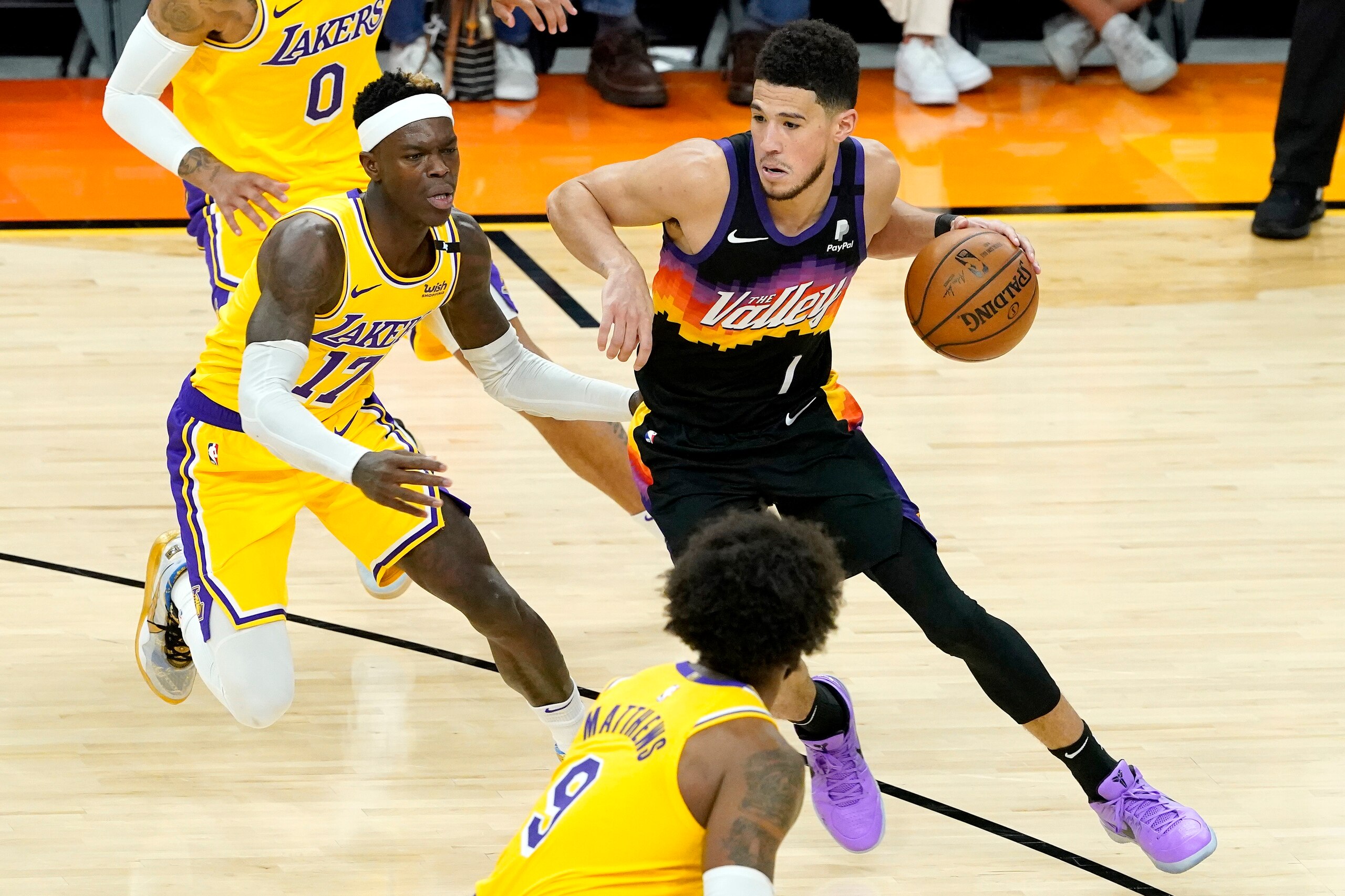 Phoenix Suns guard Devin Booker (1) drives as Los Angeles Lakers guard Dennis Schroder (17) defends during the second half of Game 5 of an NBA basketball first-round playoff series, Tuesday, June 1, 2021, in Phoenix. (AP Photo/Matt York)