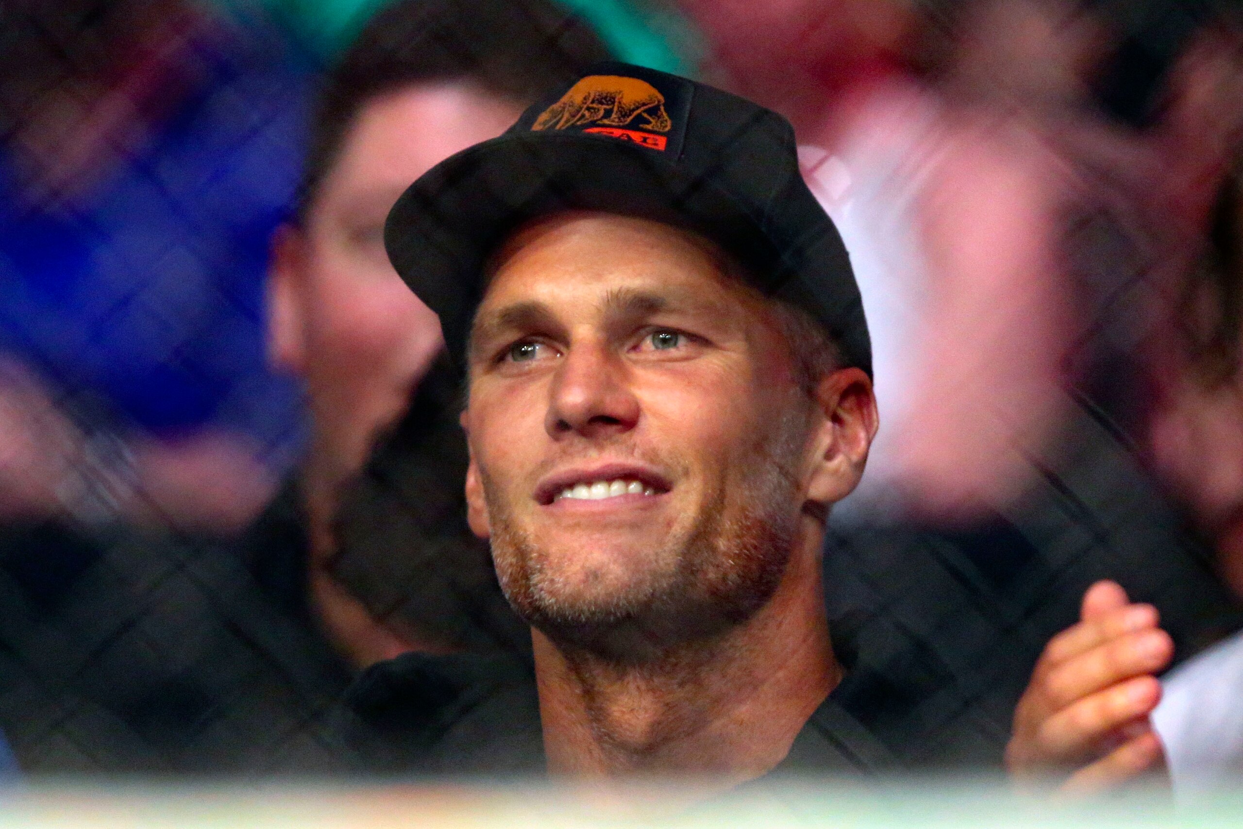 Tampa Bay Buccaneers quarterback Tom Brady watches a UFC 261 mixed martial arts bout, Saturday, April 24, 2021, in Jacksonville, Fla. It is the first UFC event since the onset of the COVID-19 pandemic to feature a full crowd in attendance. (AP Photo/Gary McCullough)