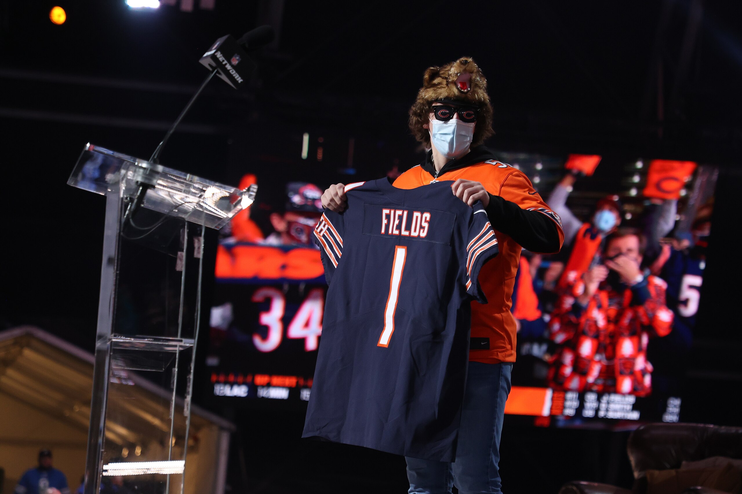 CLEVELAND, OHIO - APRIL 29: A fan holds a jersey after NFL Commissioner Roger Goodell announced Justin Fields being selected 11th by the Chicago Bears during round one of the 2021 NFL Draft at the Great Lakes Science Center on April 29, 2021 in Cleveland, Ohio. (Photo by Gregory Shamus/Getty Images) CLEVELAND, OHIO - APRIL 29: A fan holds a jersey after NFL Commissioner Roger Goodell announced Justin Fields being selected 11th by the Chicago Bears during round one of the 2021 NFL Draft at the Great Lakes Science Center on April 29, 2021 in Cleveland, Ohio. (Photo by Gregory Shamus/Getty Images)