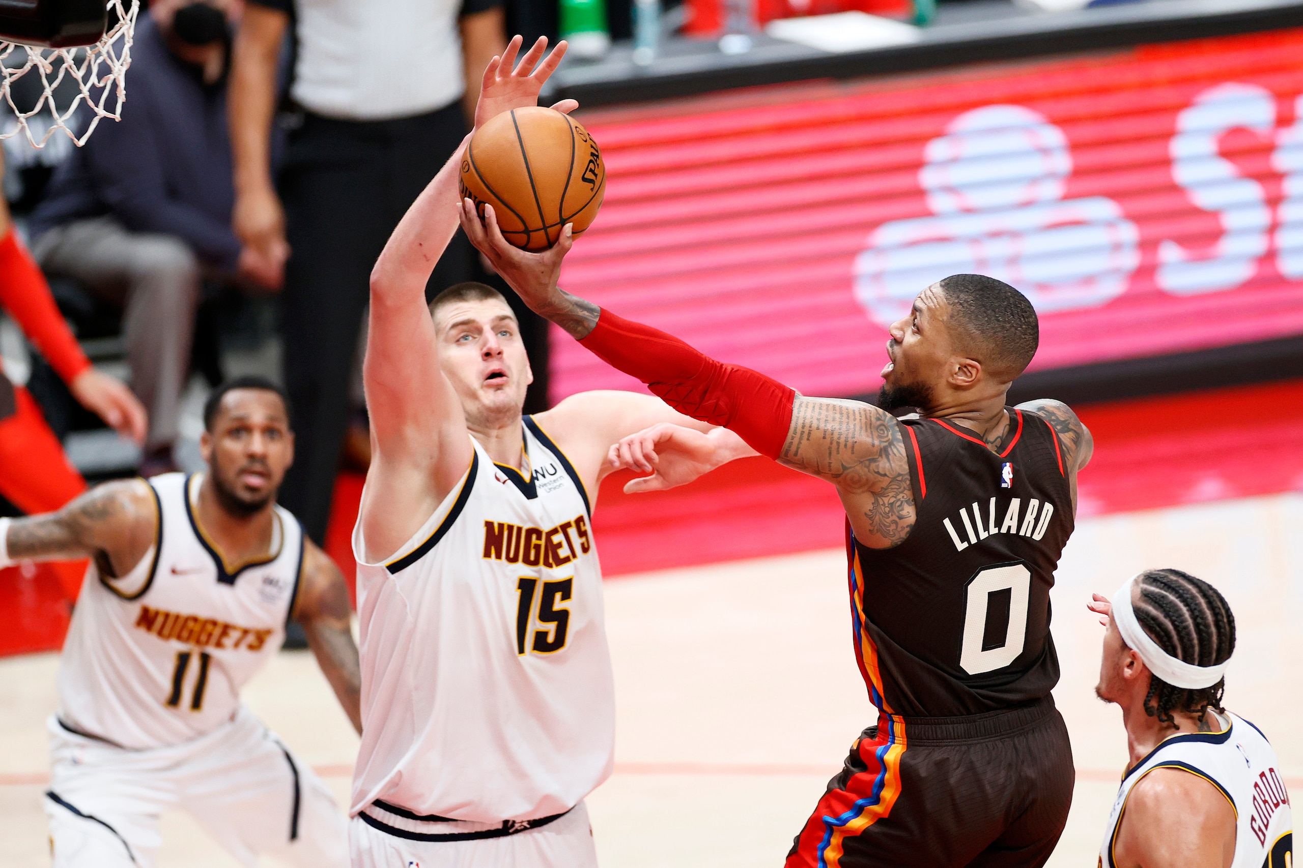 PORTLAND, OREGON - JUNE 03: Damian Lillard #0 of the Portland Trail Blazers shoots against Nikola Jokic #15 of the Denver Nuggets in the second quarter during Round 1, Game 6 of the 2021 NBA Playoffs at Moda Center on June 03, 2021 in Portland, Oregon. NOTE TO USER: User expressly acknowledges and agrees that, by downloading and or using this photograph, User is consenting to the terms and conditions of the Getty Images License Agreement. (Photo by Steph Chambers/Getty Images)