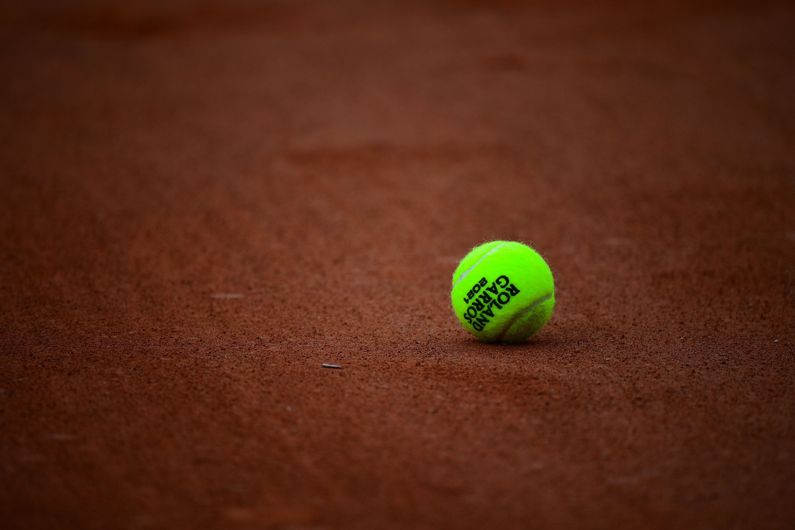 A 2021 French Open tennis tournament official ball is pictured on a court surface on Day 6 of The Roland Garros 2021 French Open tennis tournament in Paris on June 4, 2021. (Photo by Martin BUREAU / AFP) (Photo by MARTIN BUREAU/AFP via Getty Images)