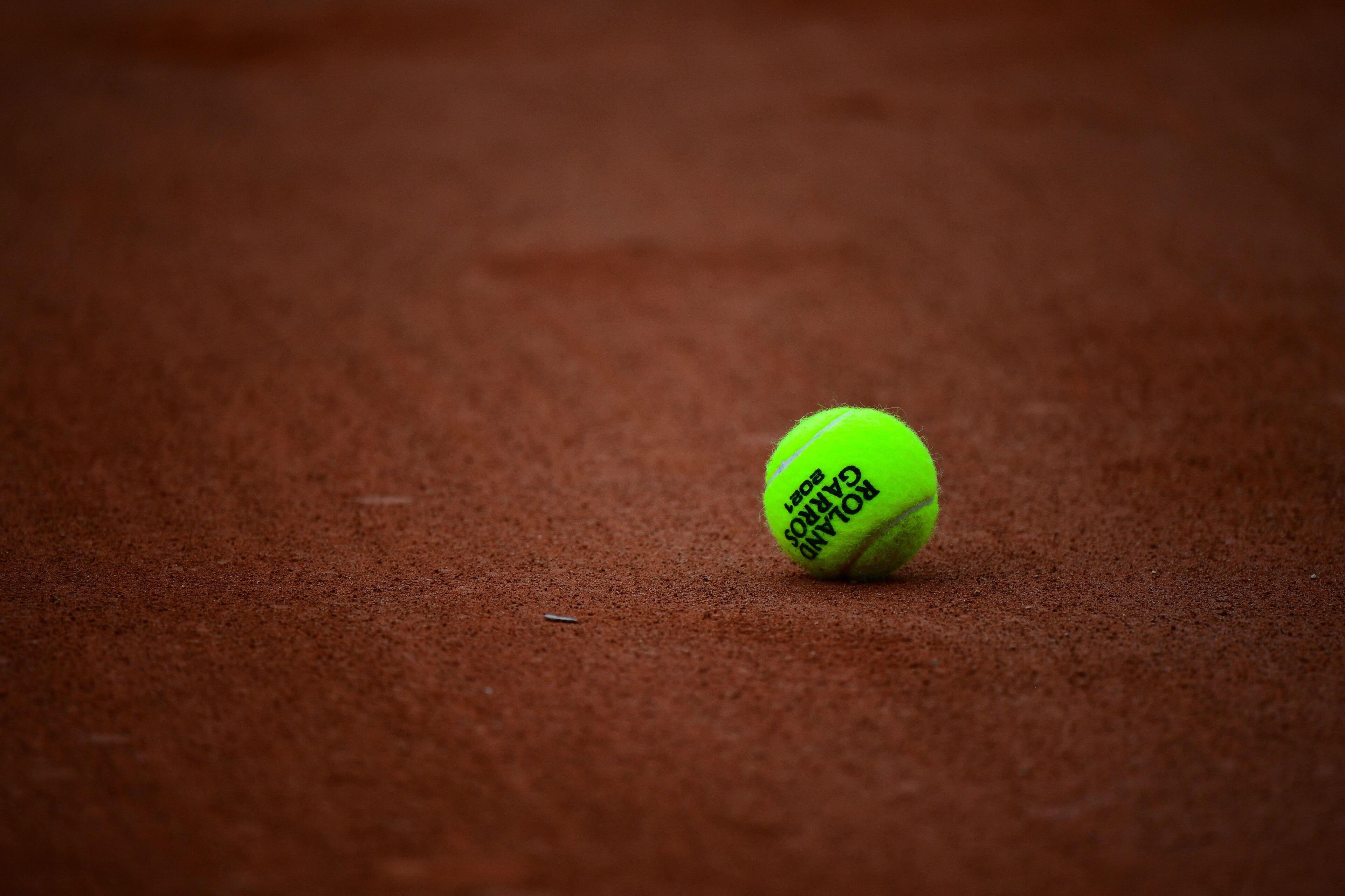 A 2021 French Open tennis tournament official ball is pictured on a court surface on Day 6 of The Roland Garros 2021 French Open tennis tournament in Paris on June 4, 2021. (Photo by Martin BUREAU / AFP) (Photo by MARTIN BUREAU/AFP via Getty Images)