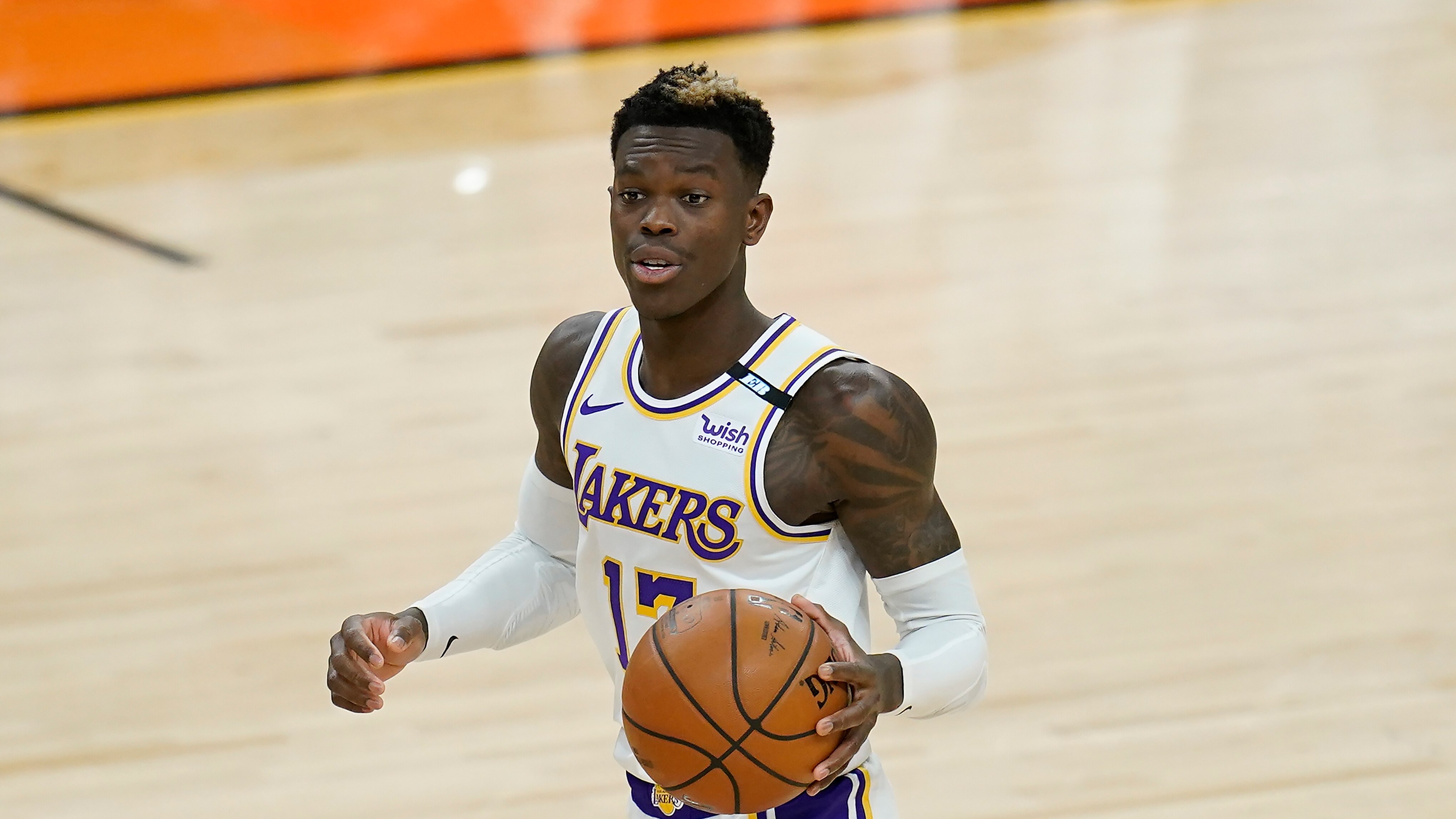 Los Angeles Lakers guard Dennis Schroder dribbles the ball against the Phoenix Suns during the first half of Game 1 of their NBA basketball first-round playoff series Sunday, May 23, 2021, in Phoenix. (AP Photo/Ross D. Franklin)