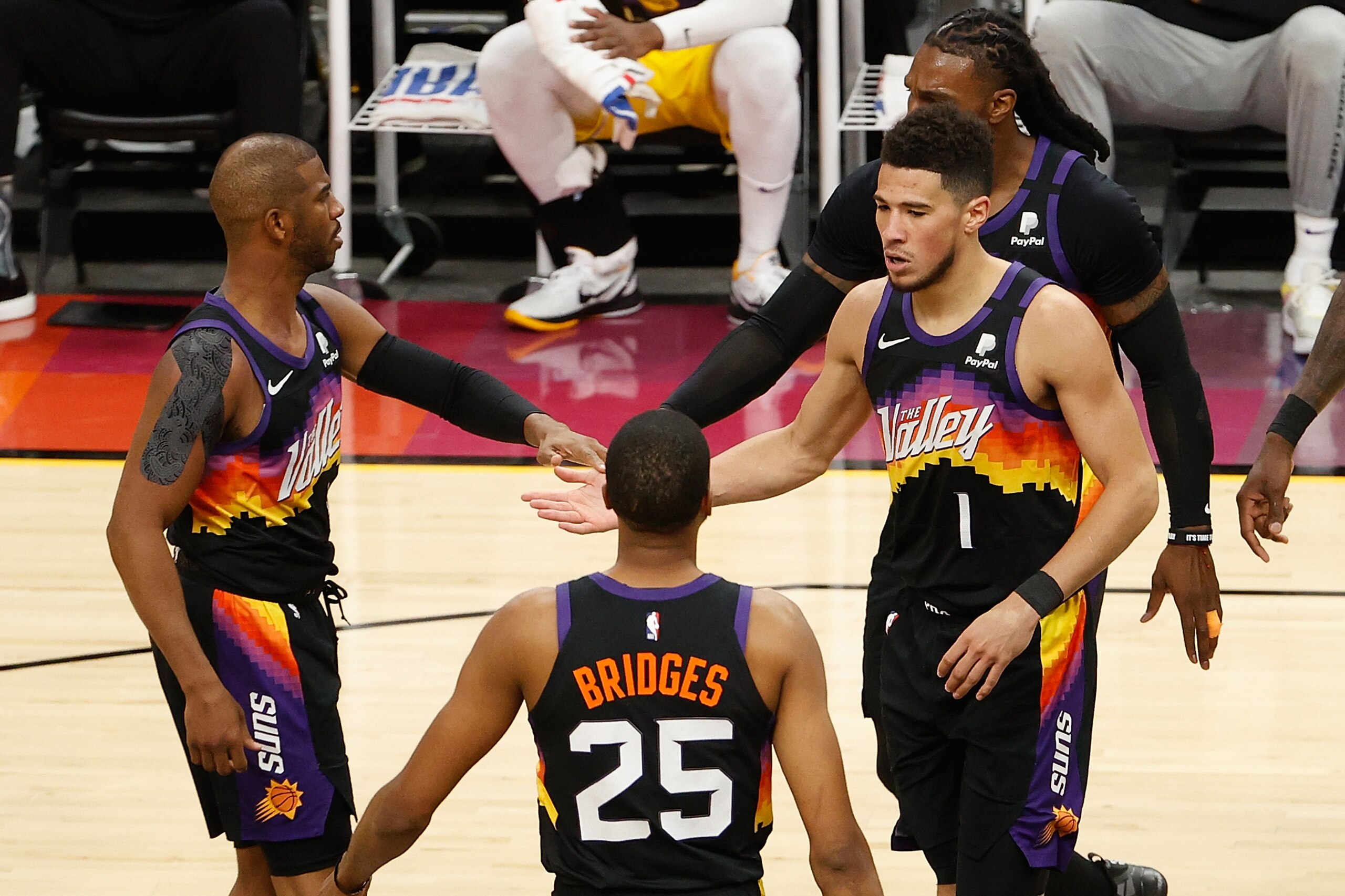 PHOENIX, ARIZONA - MAY 25: Devin Booker #1 of the Phoenix Suns high fives Chris Paul #3 and Mikal Bridges #25 after scoring against the Los Angeles Lakers during the second half of Game Two of the Western Conference first-round playoff series at Phoenix Suns Arena on May 25, 2021 in Phoenix, Arizona. NOTE TO USER: User expressly acknowledges and agrees that, by downloading and or using this photograph, User is consenting to the terms and conditions of the Getty Images License Agreement. (Photo by Christian Petersen/Getty Images) PHOENIX, ARIZONA - MAY 25: Devin Booker #1 of the Phoenix Suns high fives Chris Paul #3 and Mikal Bridges #25 after scoring against the Los Angeles Lakers during the second half of Game Two of the Western Conference first-round playoff series at Phoenix Suns Arena on May 25, 2021 in Phoenix, Arizona. NOTE TO USER: User expressly acknowledges and agrees that, by downloading and or using this photograph, User is consenting to the terms and conditions of the Getty Images License Agreement. (Photo by Christian Petersen/Getty Images)