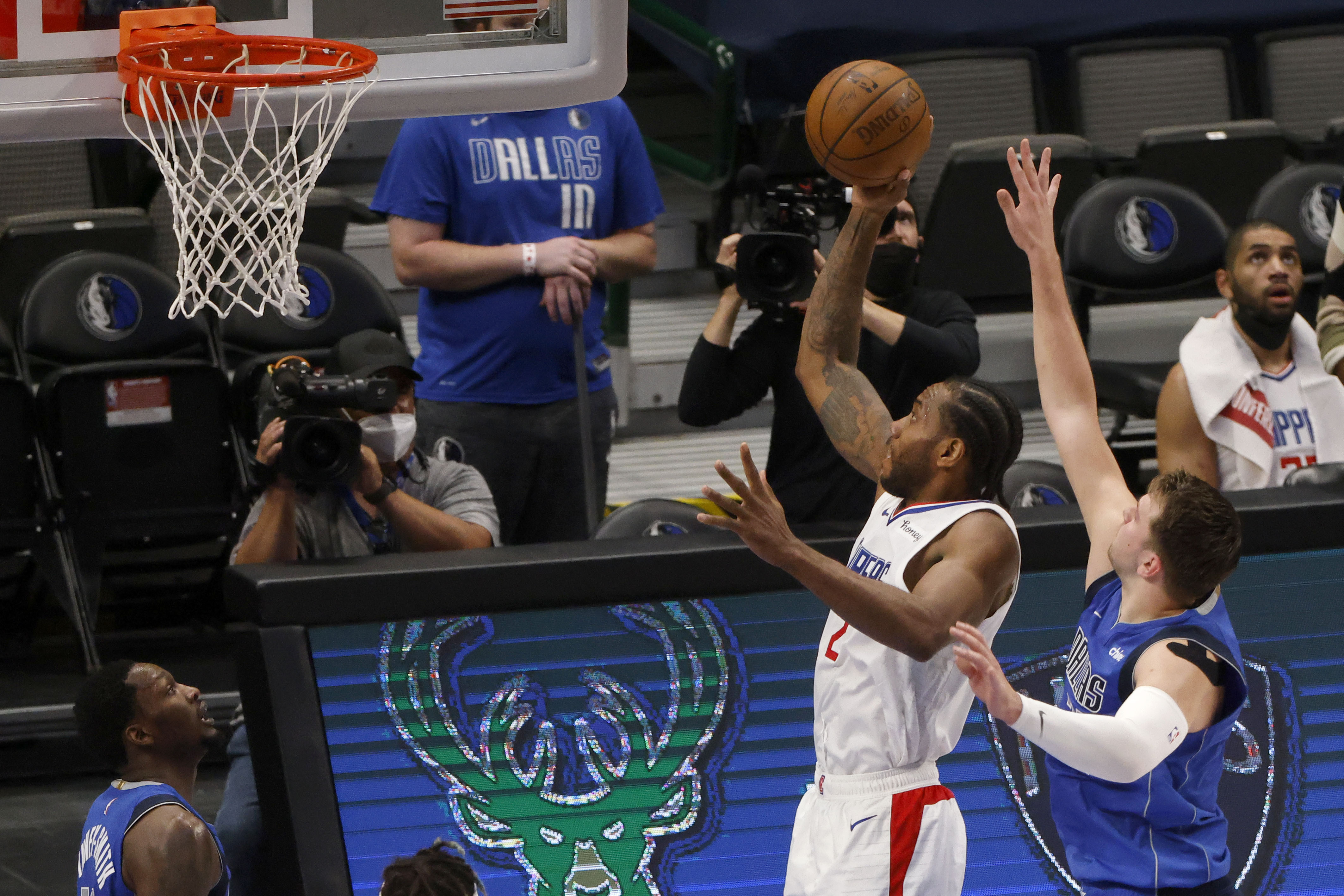 Los Angeles Clippers forward Kawhi Leonard (2) scores a basket as he is defended by Dallas Mavericks guard Luka Doncic, front right, in the first half during Game 6 of an NBA basketball first-round playoff series in Dallas, Friday, June 4, 2021. (AP Photo/Michael Ainsworth)