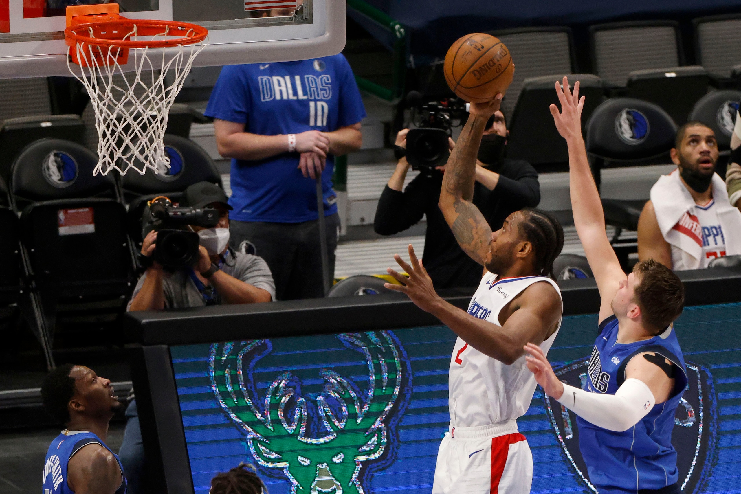 Los Angeles Clippers forward Kawhi Leonard (2) scores a basket as he is defended by Dallas Mavericks guard Luka Doncic, front right, in the first half during Game 6 of an NBA basketball first-round playoff series in Dallas, Friday, June 4, 2021. (AP Photo/Michael Ainsworth)