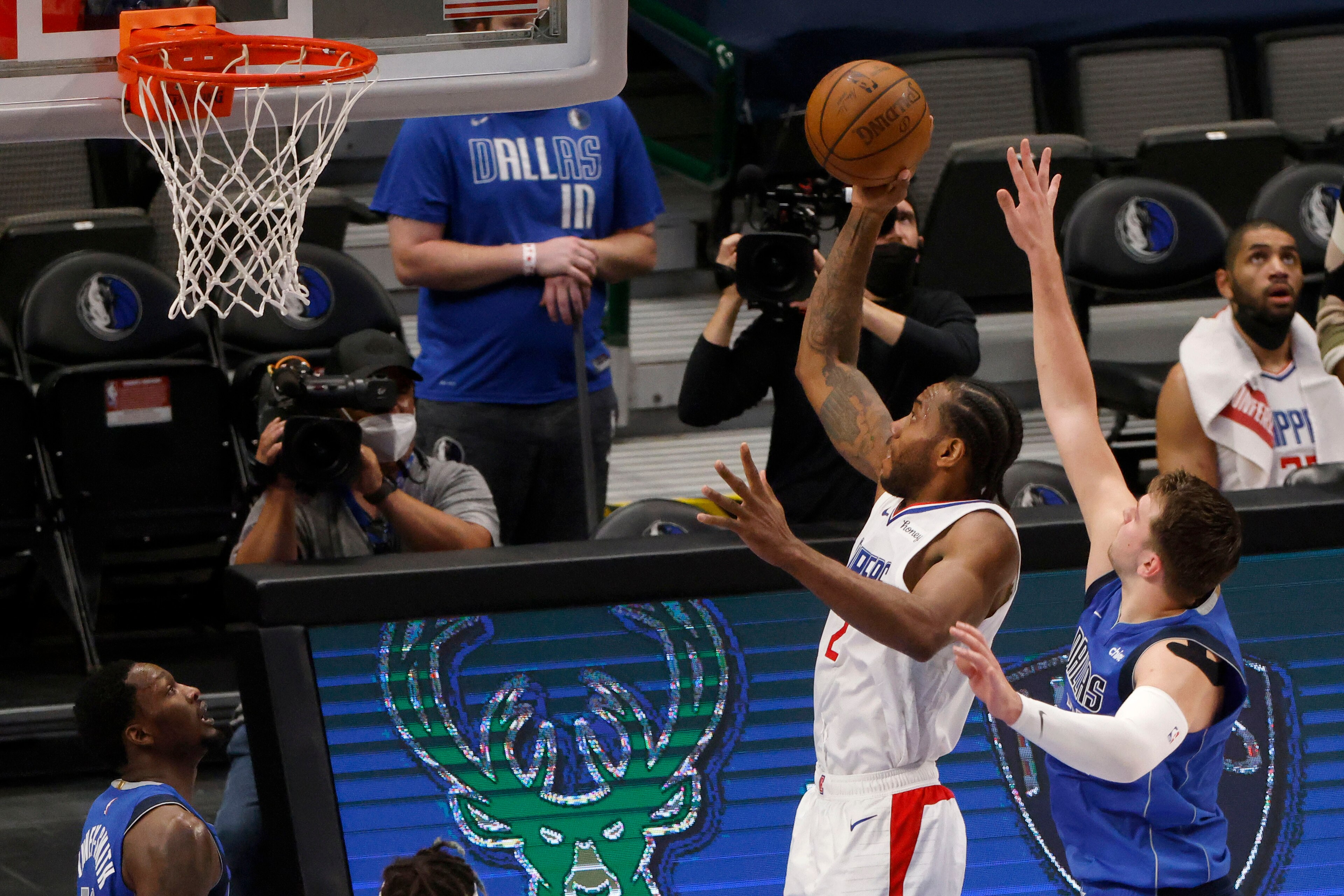 Los Angeles Clippers forward Kawhi Leonard (2) scores a basket as he is defended by Dallas Mavericks guard Luka Doncic, front right, in the first half during Game 6 of an NBA basketball first-round playoff series in Dallas, Friday, June 4, 2021. (AP Photo/Michael Ainsworth)