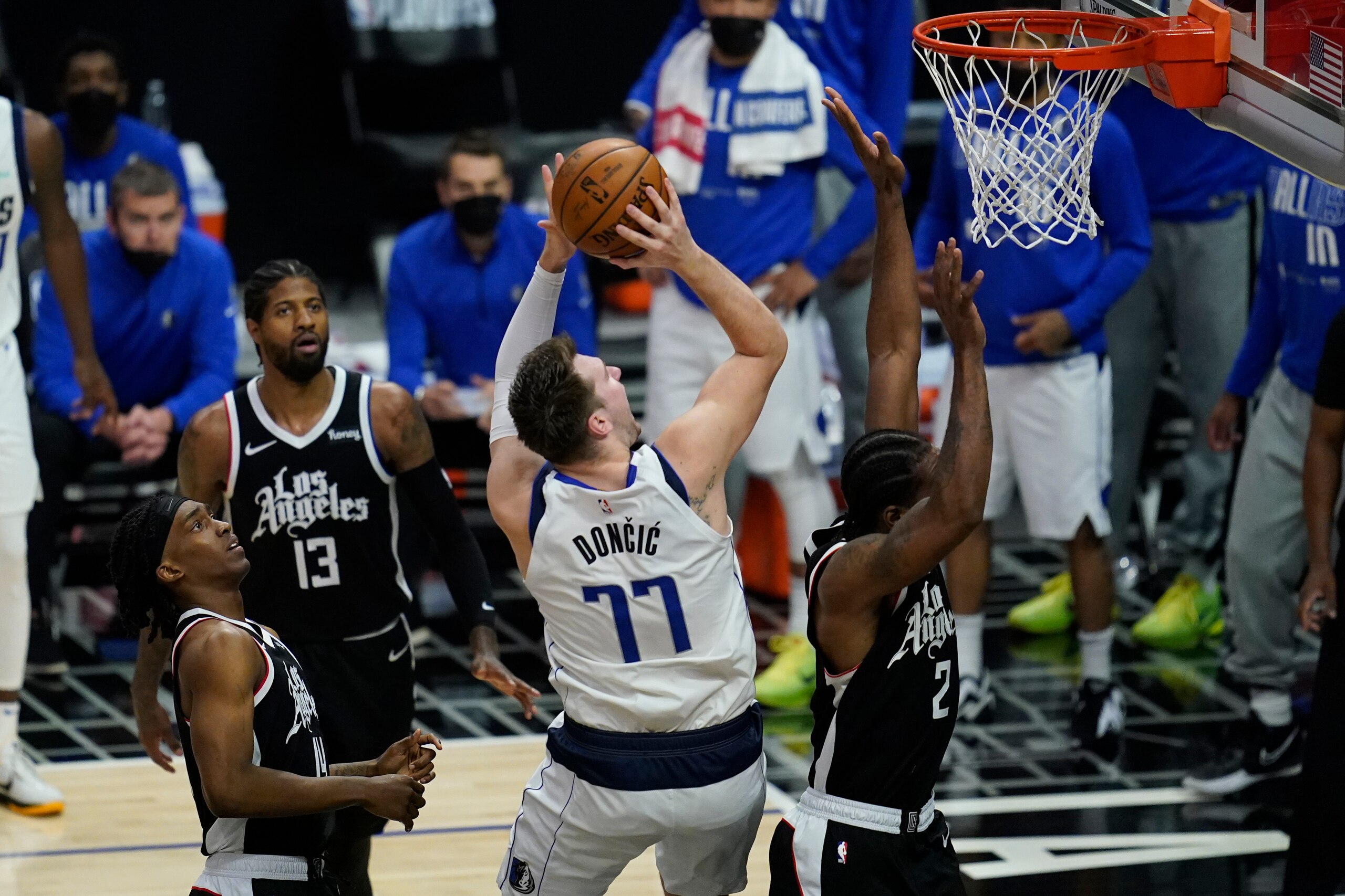 Dallas Mavericks guard Luka Doncic (77) shoots against Los Angeles Clippers guard Terance Mann, left, guard Paul George (13) and forward Kawhi Leonard (2) during the second quarter of Game 7 of an NBA basketball first-round playoff series Sunday, June 6, 2021, in Los Angeles, Calif. (AP Photo/Ashley Landis)