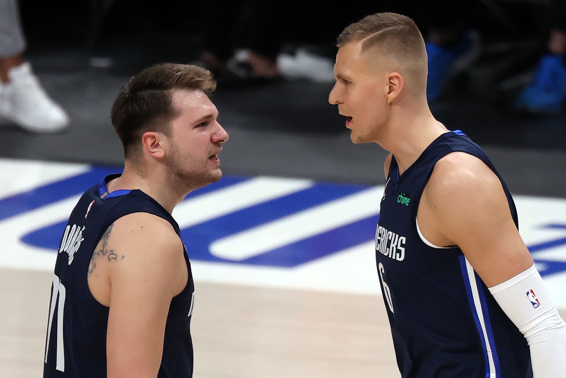 DALLAS, TEXAS - MAY 28:  Luka Doncic #77 and Kristaps Porzingis #6 of the Dallas Mavericks react against the LA Clippers in the first quarter in game three of the Western Conference first round series at American Airlines Center on May 28, 2021 in Dallas, Texas.  NOTE TO USER: User expressly acknowledges and agrees that, by downloading and or using this photograph, User is consenting to the terms and conditions of the Getty Images License Agreement. (Photo by Ronald Martinez/Getty Images)