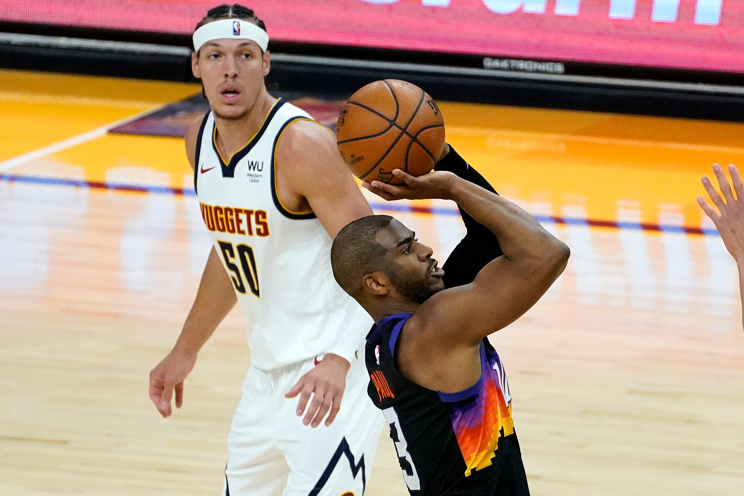 Phoenix Suns guard Chris Paul (3) shoots as Denver Nuggets forward Aaron Gordon (50) looks on during the second half of Game 1 of an NBA basketball second-round playoff series, Monday, June 7, 2021, in Phoenix. (AP Photo/Matt York)