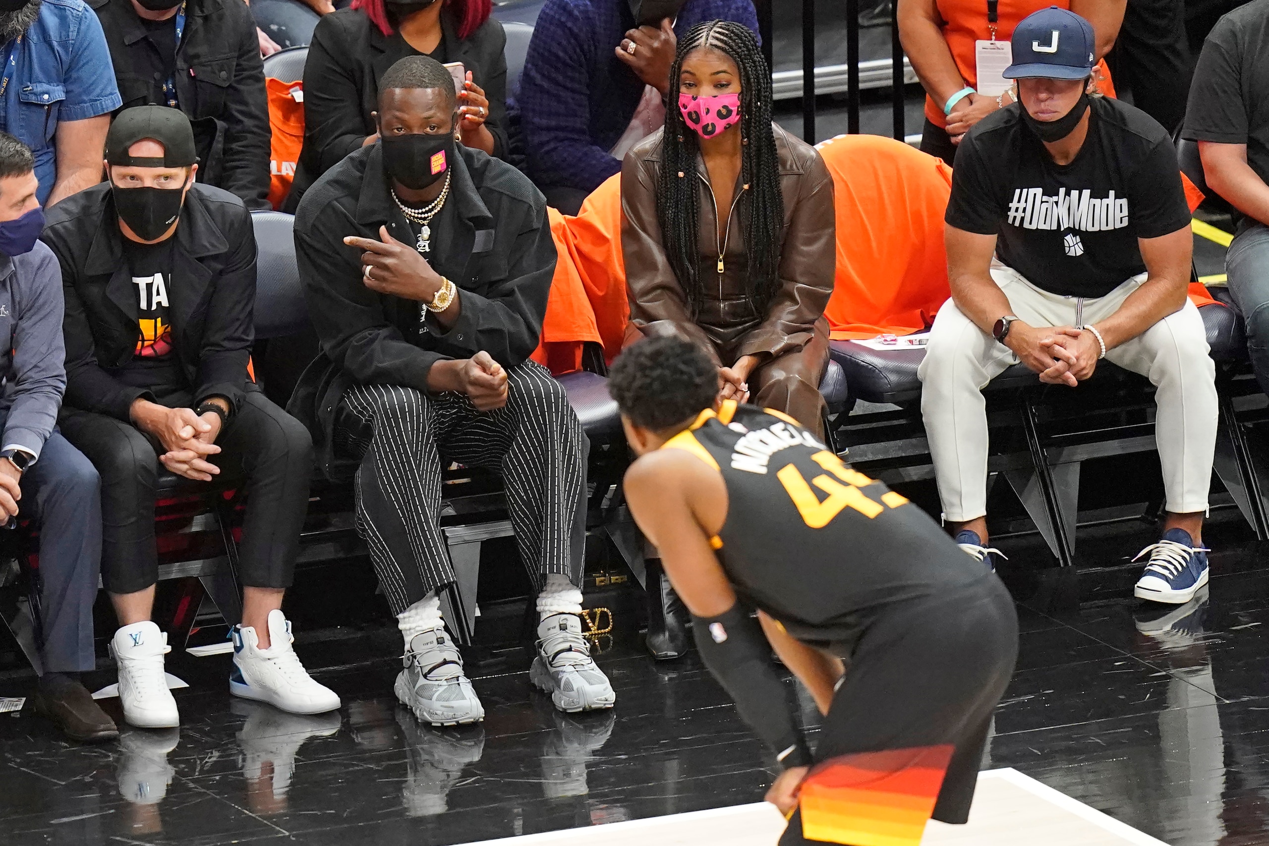 Utah Jazz owner Dwyane Wade speaks with Donovan Mitchell during the second half of Game 1 of a second-round NBA basketball playoff series against the Los Angeles Clippers Tuesday, June 8, 2021, in Salt Lake City. (AP Photo/Rick Bowmer)