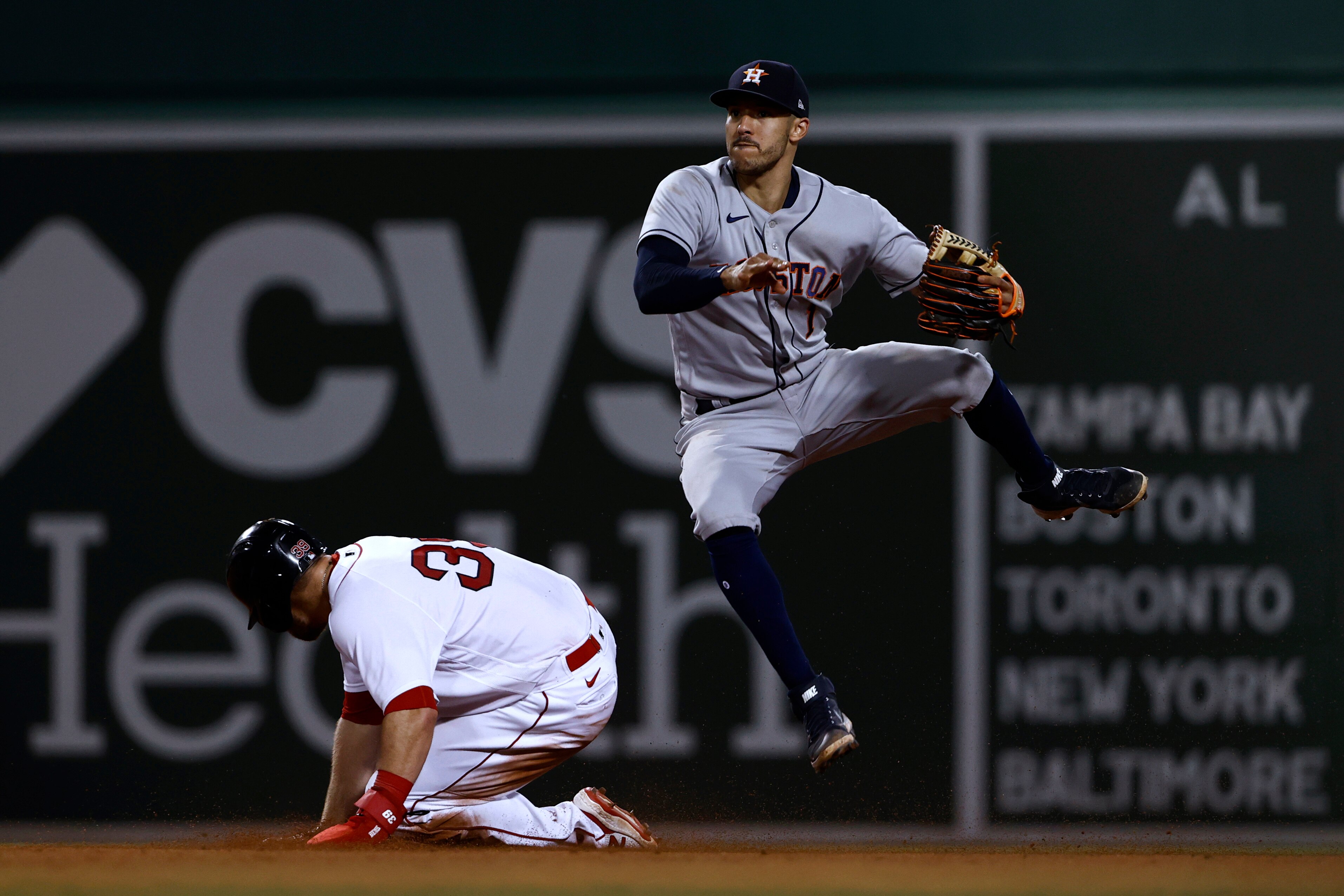 Houston Astros shortstop Carlos Correa dodges a sliding Boston Red Sox's Christian Arroyo after forcing him out during the eighth inning of a baseball game Tuesday, June 8, 2021, at Fenway Park in Boston. Rafael Devers was safe at first. (AP Photo/Winslow Townson)