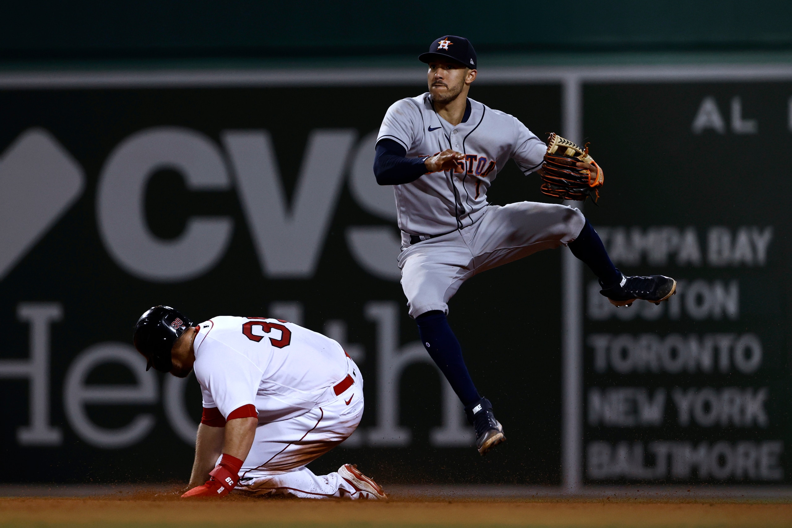 Houston Astros shortstop Carlos Correa dodges a sliding Boston Red Sox's Christian Arroyo after forcing him out during the eighth inning of a baseball game Tuesday, June 8, 2021, at Fenway Park in Boston. Rafael Devers was safe at first. (AP Photo/Winslow Townson)