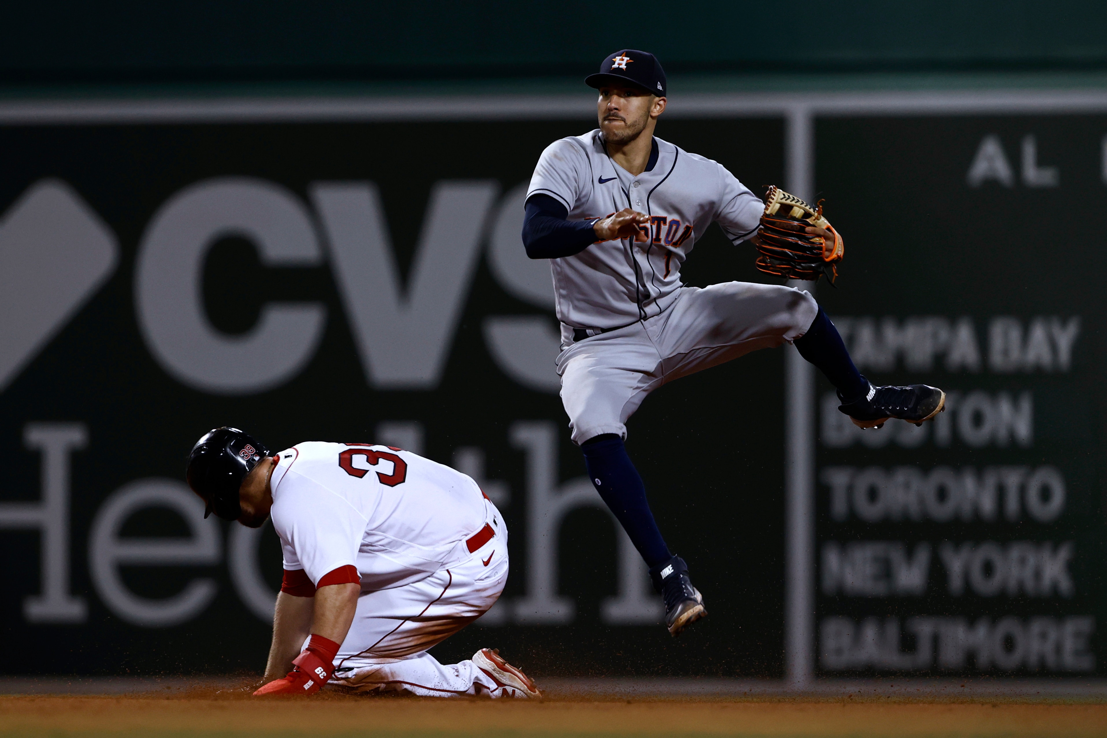 Houston Astros shortstop Carlos Correa dodges a sliding Boston Red Sox's Christian Arroyo after forcing him out during the eighth inning of a baseball game Tuesday, June 8, 2021, at Fenway Park in Boston. Rafael Devers was safe at first. (AP Photo/Winslow Townson)