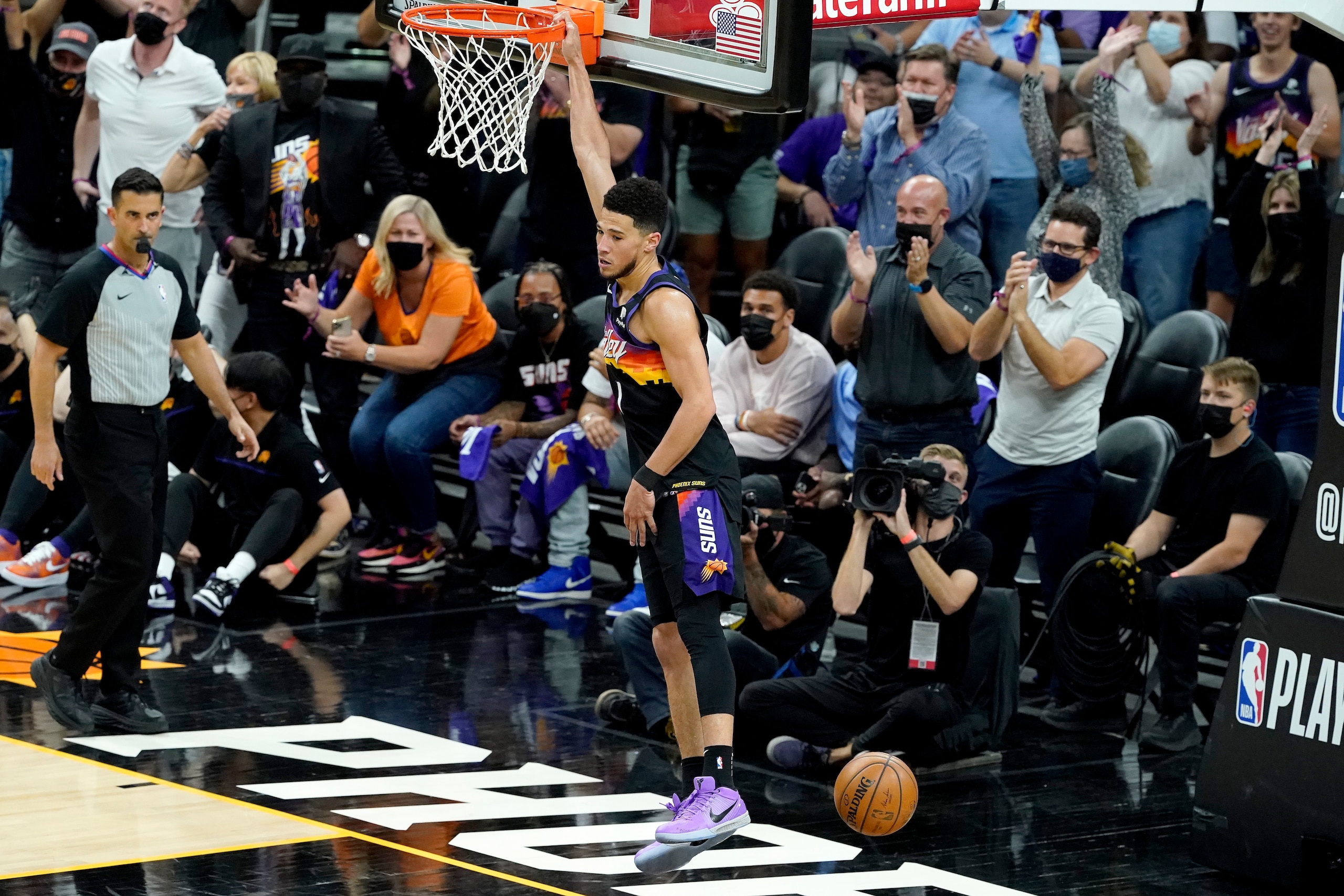 Phoenix Suns guard Devin Booker (1) dunks against the Denver Nuggets during the first half of Game 2 of an NBA basketball second-round playoff series, Wednesday, June 9, 2021, in Phoenix. (AP Photo/Matt York)