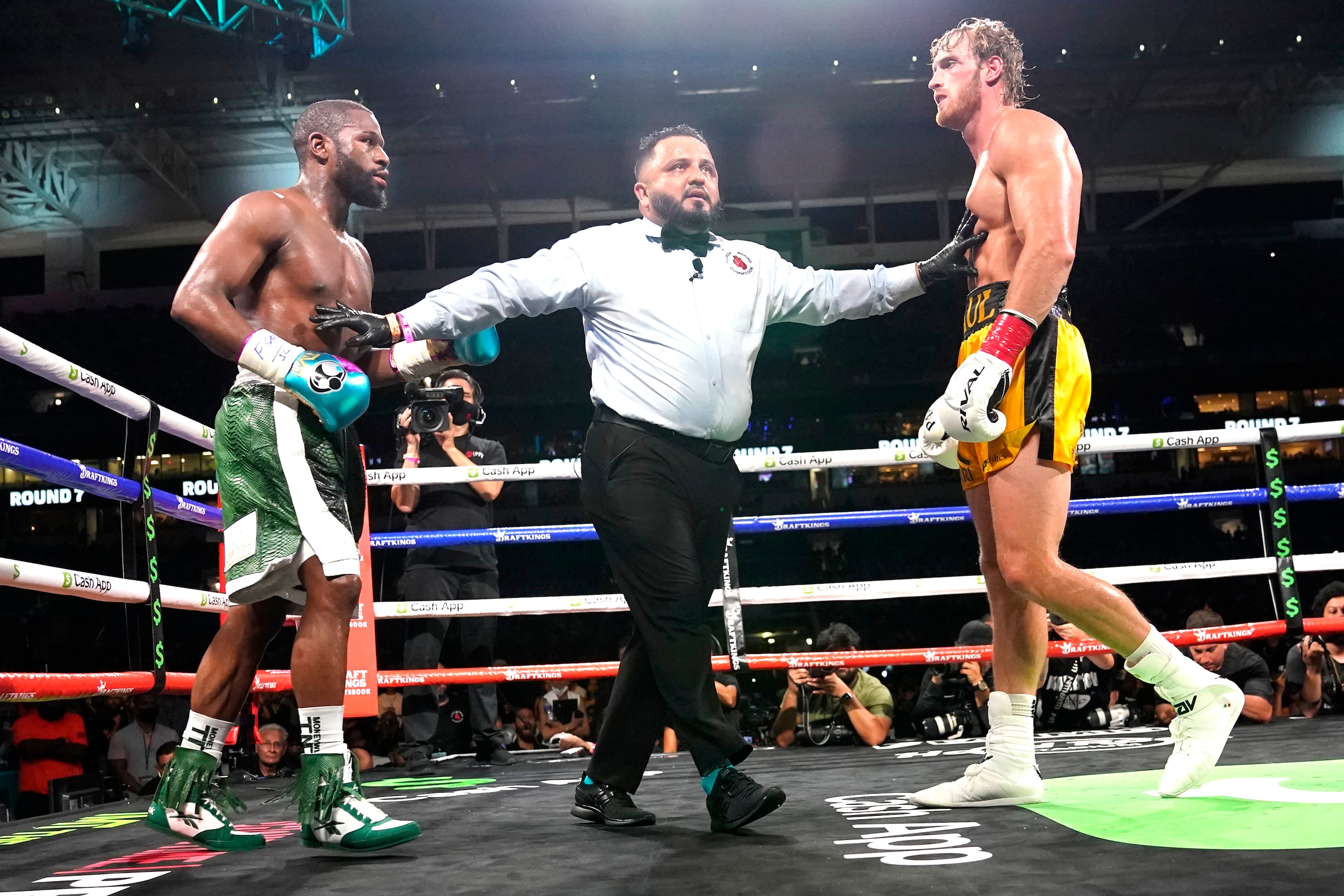 Floyd Mayweather, left, and Logan Paul, right, are held apart during an exhibition boxing match at Hard Rock Stadium, Sunday, June 6, 2021, in Miami Gardens, Fla. (AP Photo/Lynne Sladky)