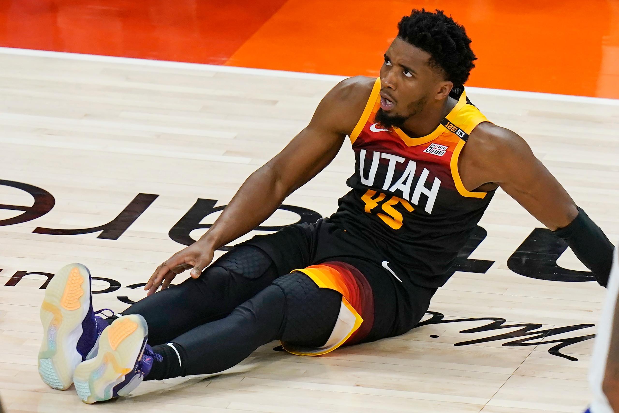 Utah Jazz guard Donovan Mitchell (45) reaches for his leg after being fouled by Los Angeles Clippers guard Paul George during the second half of Game 2 of a second-round NBA basketball playoff series Thursday, June 10, 2021, in Salt Lake City. (AP Photo/Rick Bowmer)