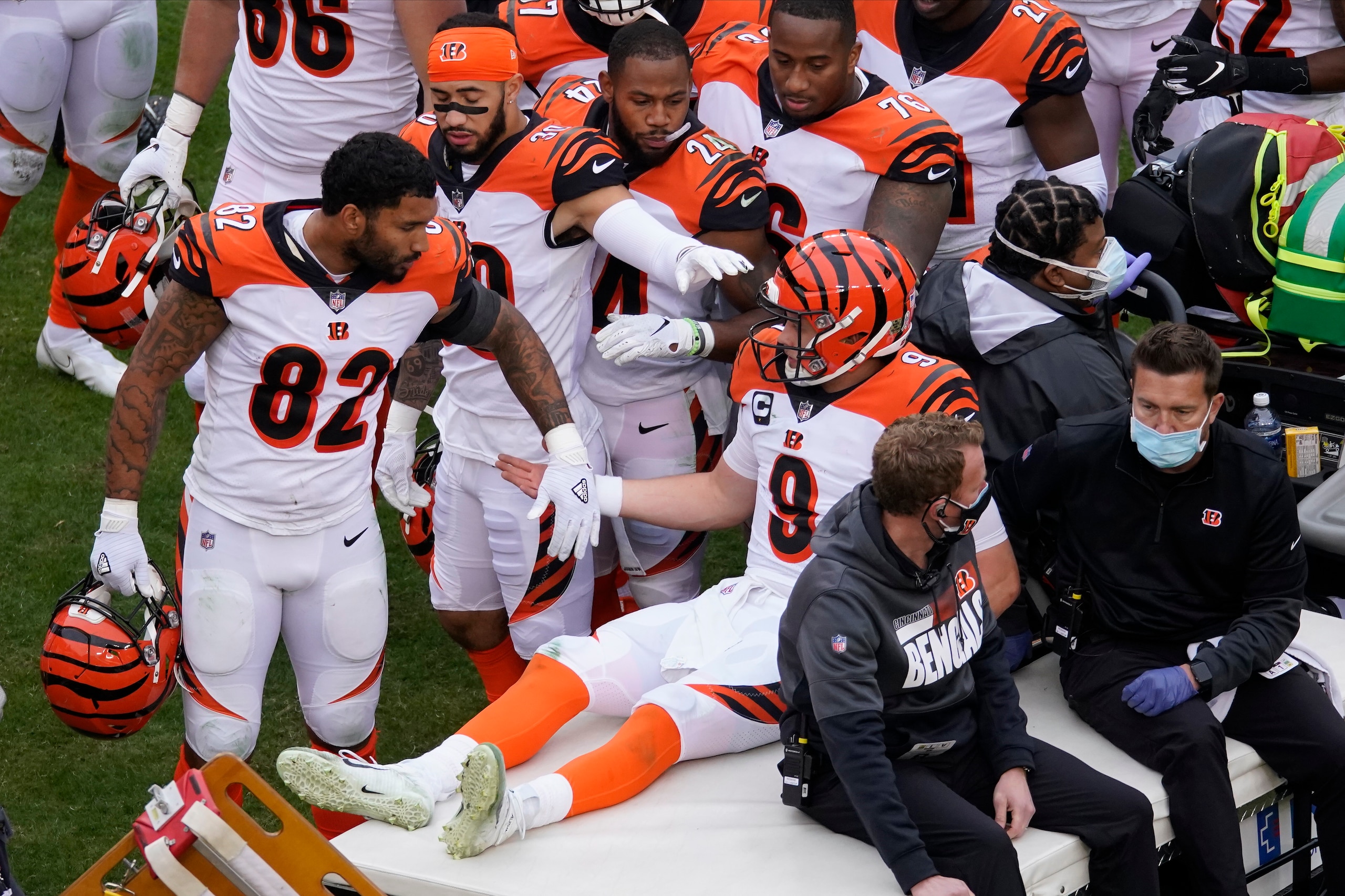 Cincinnati Bengals quarterback Joe Burrow (9) is consoled by teammates as he is moved off the field after injuring his left knee following a play in the second half of an NFL football game against the Washington Football Team, Sunday, Nov. 22, 2020, in Landover, Md. (AP Photo/Al Drago)