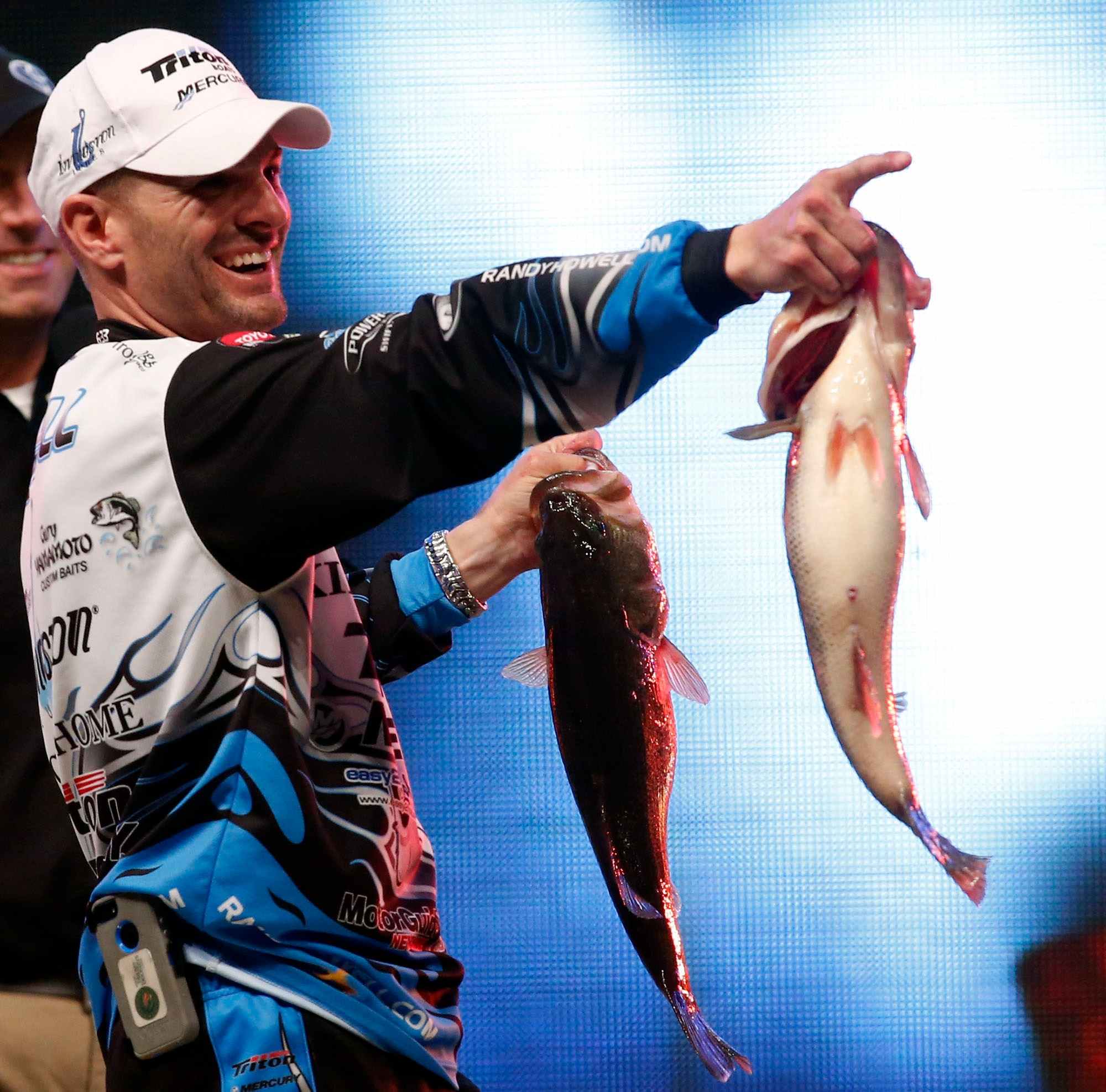 Randy Howell, Springville, Ala., points to family and supporters as he holds up two bass at the weigh-in,  Sunday Feb. 23, 2014 in Birmingham, Ala. that helped him to win the Bassmaster Classic on Lake Guntersville. (AP Photo/Hal Yeager)