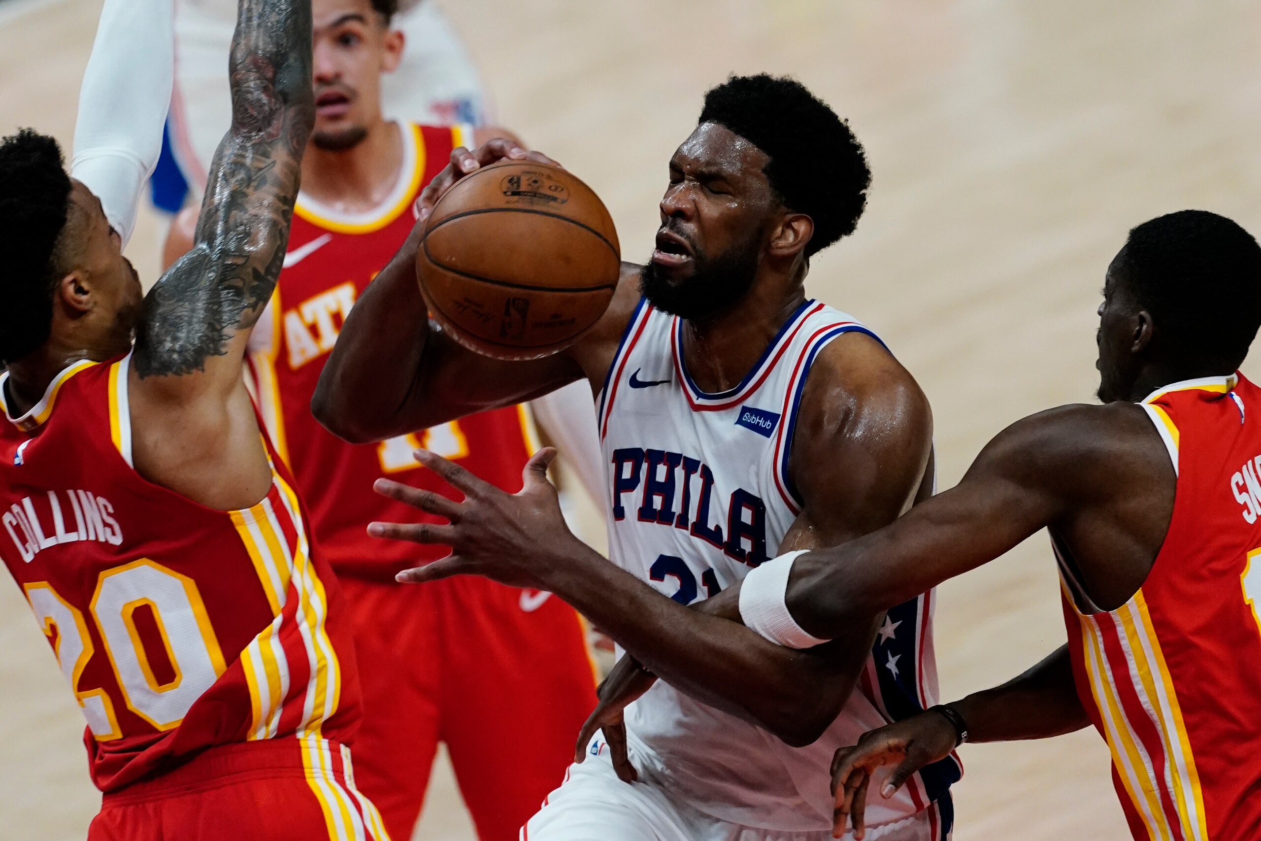Philadelphia 76ers center Joel Embiid (21) is fouled by Atlanta Hawks forward Tony Snell (19), right, as Hawks forward John Collins (20) defends during the first half of Game 3 of a second-round NBA basketball playoff series, Friday, June 11, 2021, in Atlanta. (AP Photo/John Bazemore)