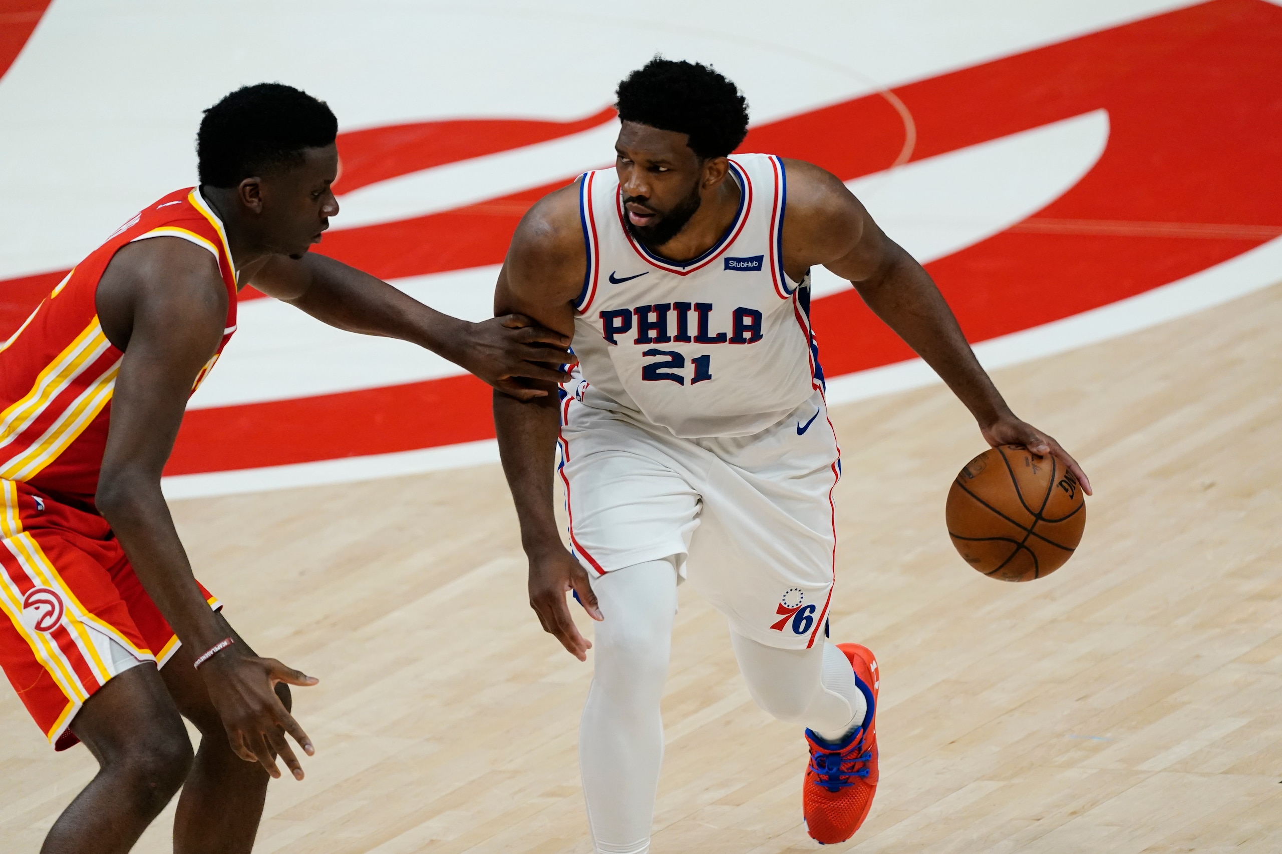 Philadelphia 76ers center Joel Embiid (21) is defended by Atlanta Hawks center Clint Capela (15) during the first half of Game 3 of a second-round NBA basketball playoff series, Friday, June 11, 2021, in Atlanta. (AP Photo/John Bazemore)