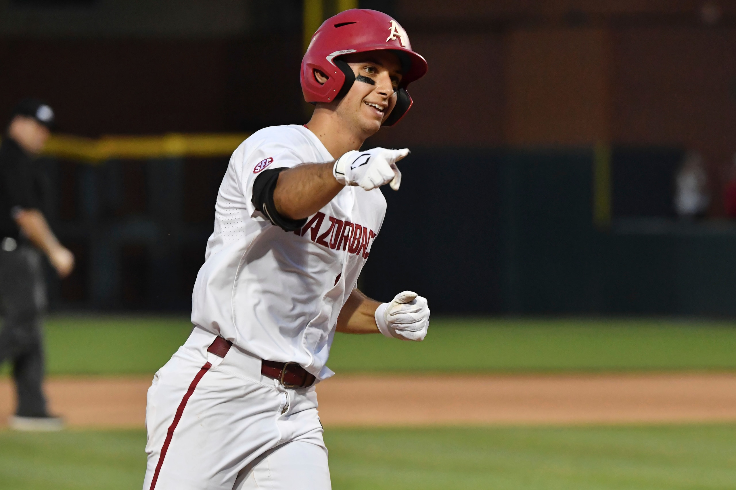 Arkansas batter Robert Moore celebrates as he rounds the basses after hitting his second home run against North Carolina State, in the eighth inning of an NCAA college baseball super regional game Friday, June 11, 2021, in Fayetteville, Ark. (AP Photo/Michael Woods)