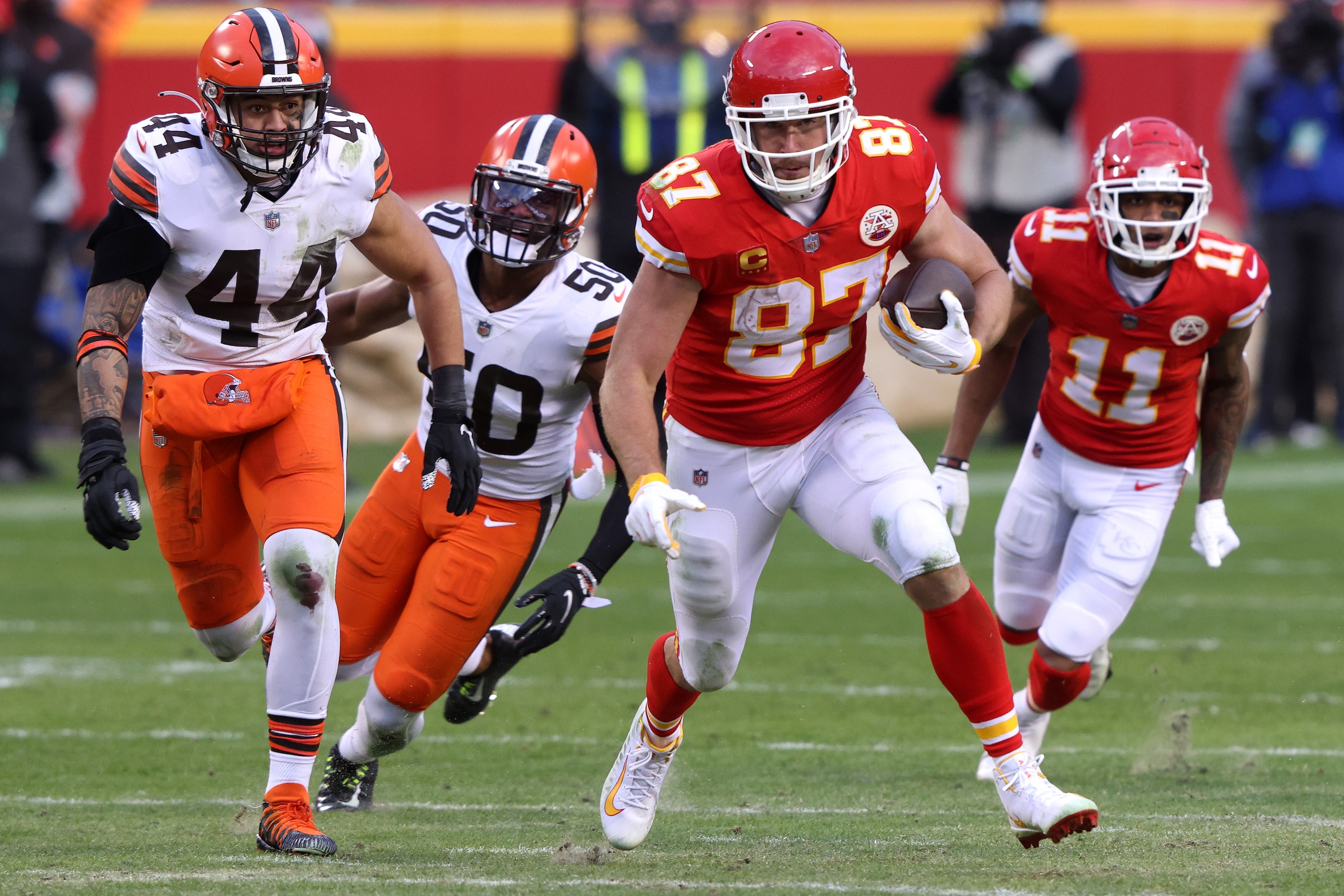 KANSAS CITY, MISSOURI - JANUARY 17: Tight end Travis Kelce #87 of the Kansas City Chiefs carries the football over outside linebacker Sione Takitaki #44 of the Cleveland Browns after complete a catch during the fourth quarter of the AFC Divisional Playoff game at Arrowhead Stadium on January 17, 2021 in Kansas City, Missouri. (Photo by Jamie Squire/Getty Images)