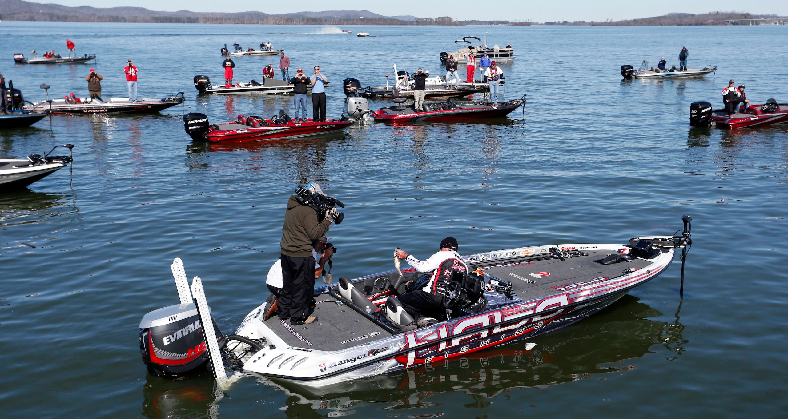 Randall Tharp, Port Saint Joe, Fla., holds up a bass for spectators following him on the second day of the Bassmaster Classic, Saturday, Feb. 22, 2014, in Guntersville, Ala. Tharp was bumped from first to second by 1 ounce by Edwin Evers, Talala, Okla. The field will be cut to the top 25 anglers for the final day of competition. (AP Photo/Hal Yeager)