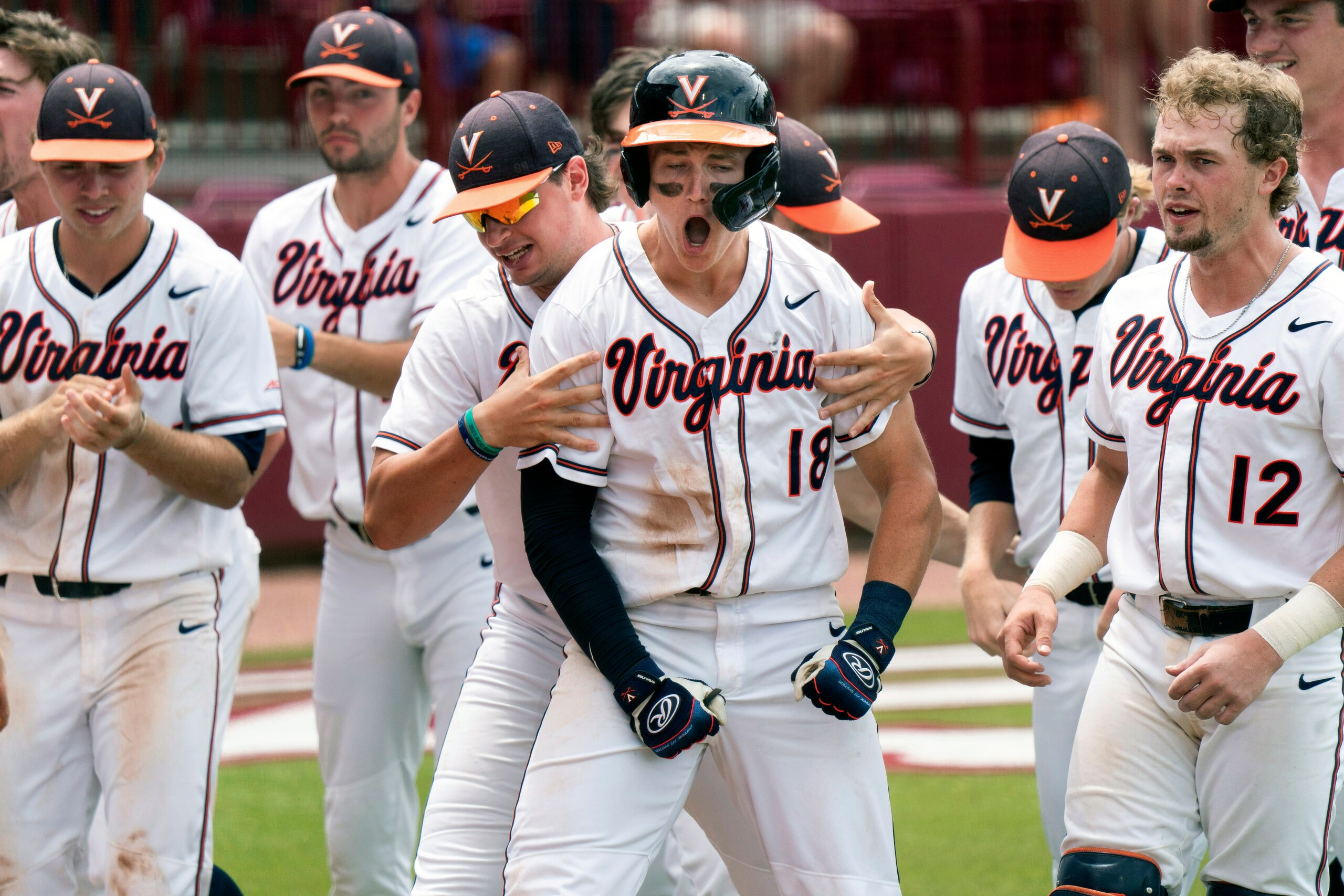 Virginia's Zack Gelof (18) celebrates his eighth inning home run with Christian Hlinka, left, Logan Michaels (12) and other teammates during an NCAA college baseball tournament super regional game against Dallas Baptist Saturday, June 13, 2021, in Columbia, S.C. Virginia won 4-0. (AP Photo/Sean Rayford) Virginia's Zack Gelof (18) celebrates his eighth inning home run with Christian Hlinka, left, Logan Michaels (12) and other teammates during an NCAA college baseball tournament super regional game against Dallas Baptist Saturday, June 13, 2021, in Columbia, S.C. Virginia won 4-0. (AP Photo/Sean Rayford)