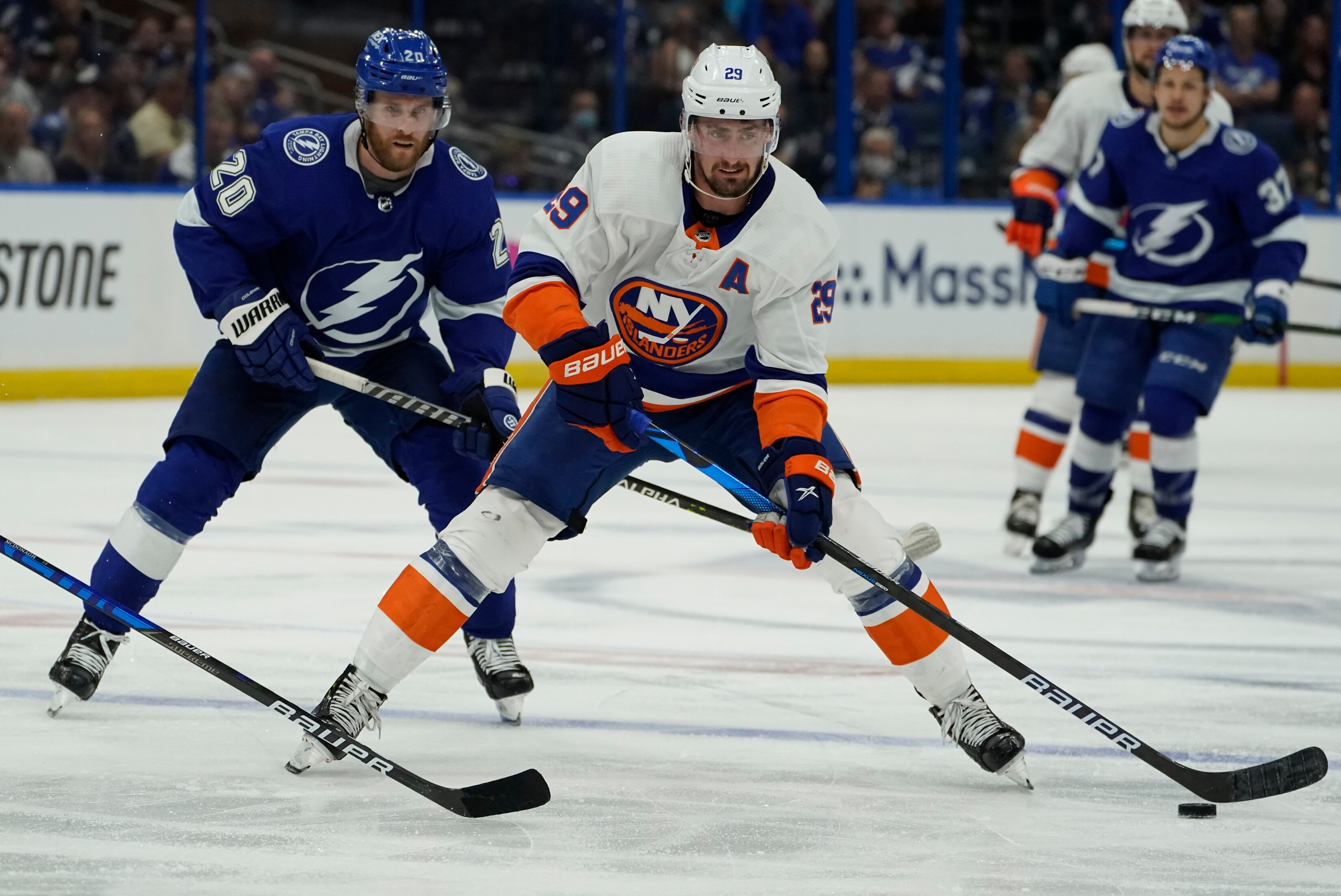 New York Islanders center Brock Nelson (29) moves the pu8ck in front of Tampa Bay Lightning center Blake Coleman (20) during the third period in Game 1 of an NHL hockey Stanley Cup semifinal playoff series Sunday, June 13, 2021, in Tampa, Fla. (AP Photo/Chris O'Meara)