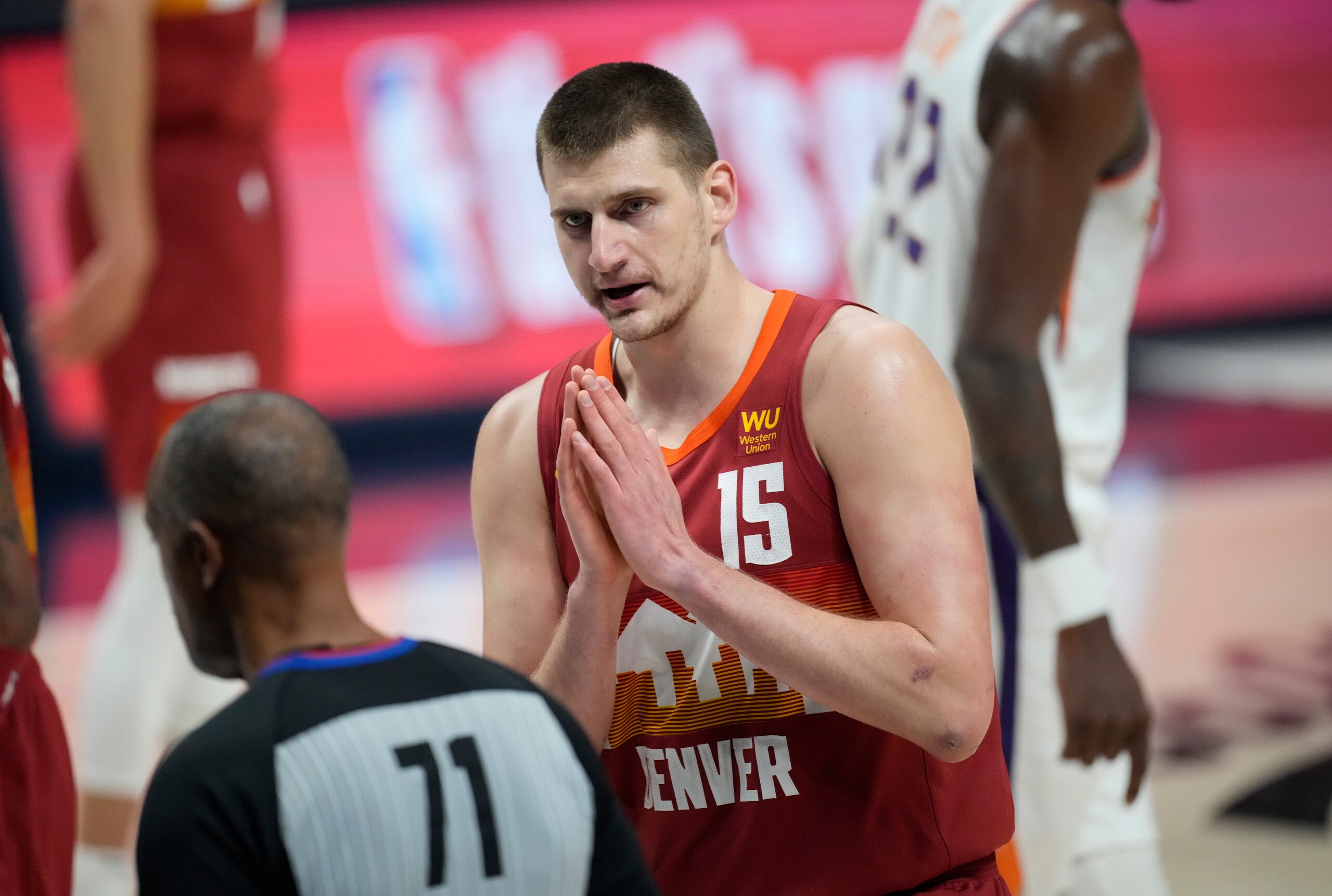 Denver Nuggets center Nikola Jokic (15) argues for a call with referee Rodney Mott (71) in the first half of Game 4 of an NBA second-round playoff series against the Phoenix Suns, Sunday, June 13, 2021, in Denver. (AP Photo/David Zalubowski)