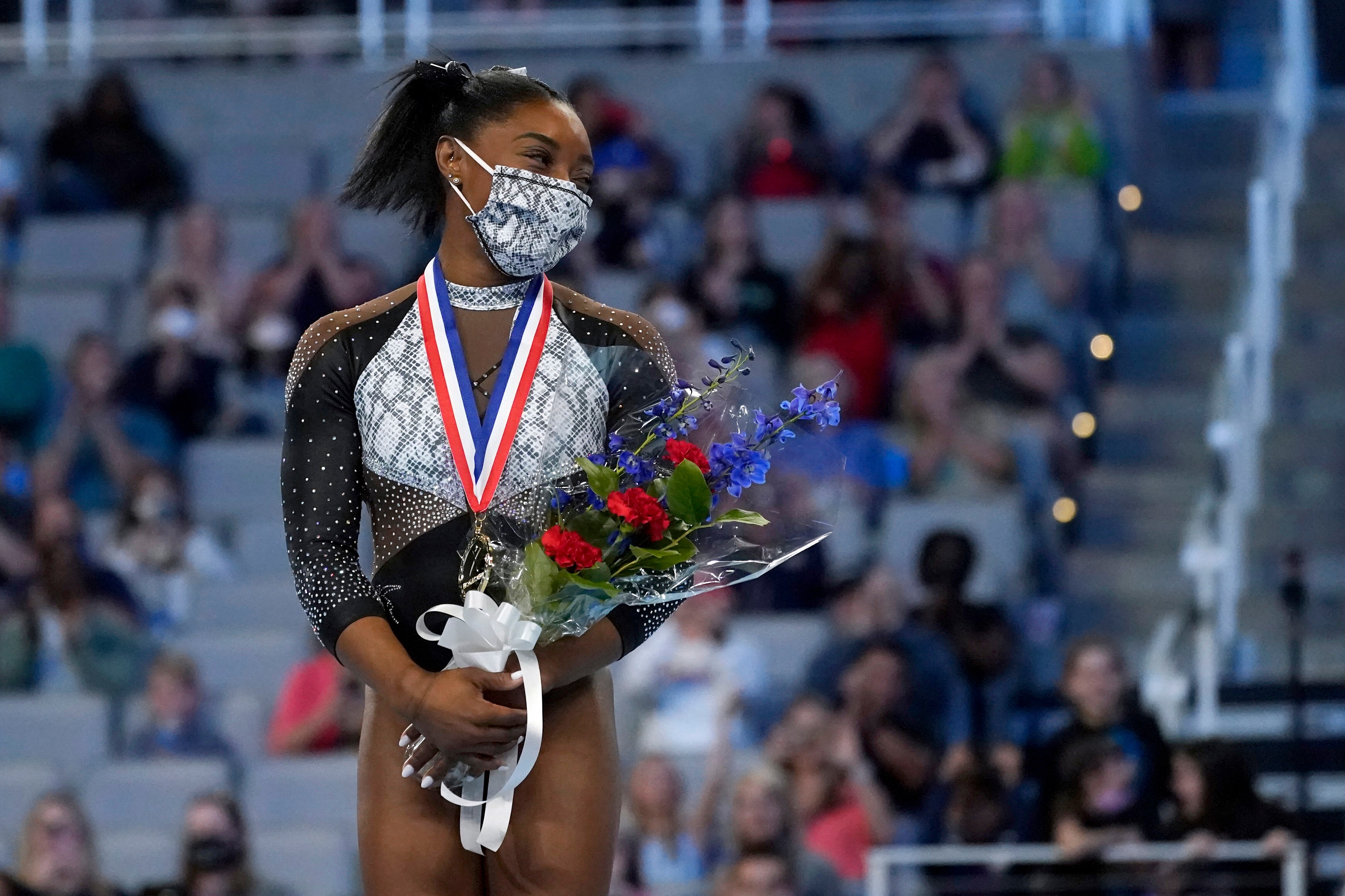 Simone Biles stands on the podium after earning first place in the all around following the U.S. Gymnastics Championships, Sunday, June 6, 2021, in Fort Worth, Texas. (AP Photo/Tony Gutierrez)