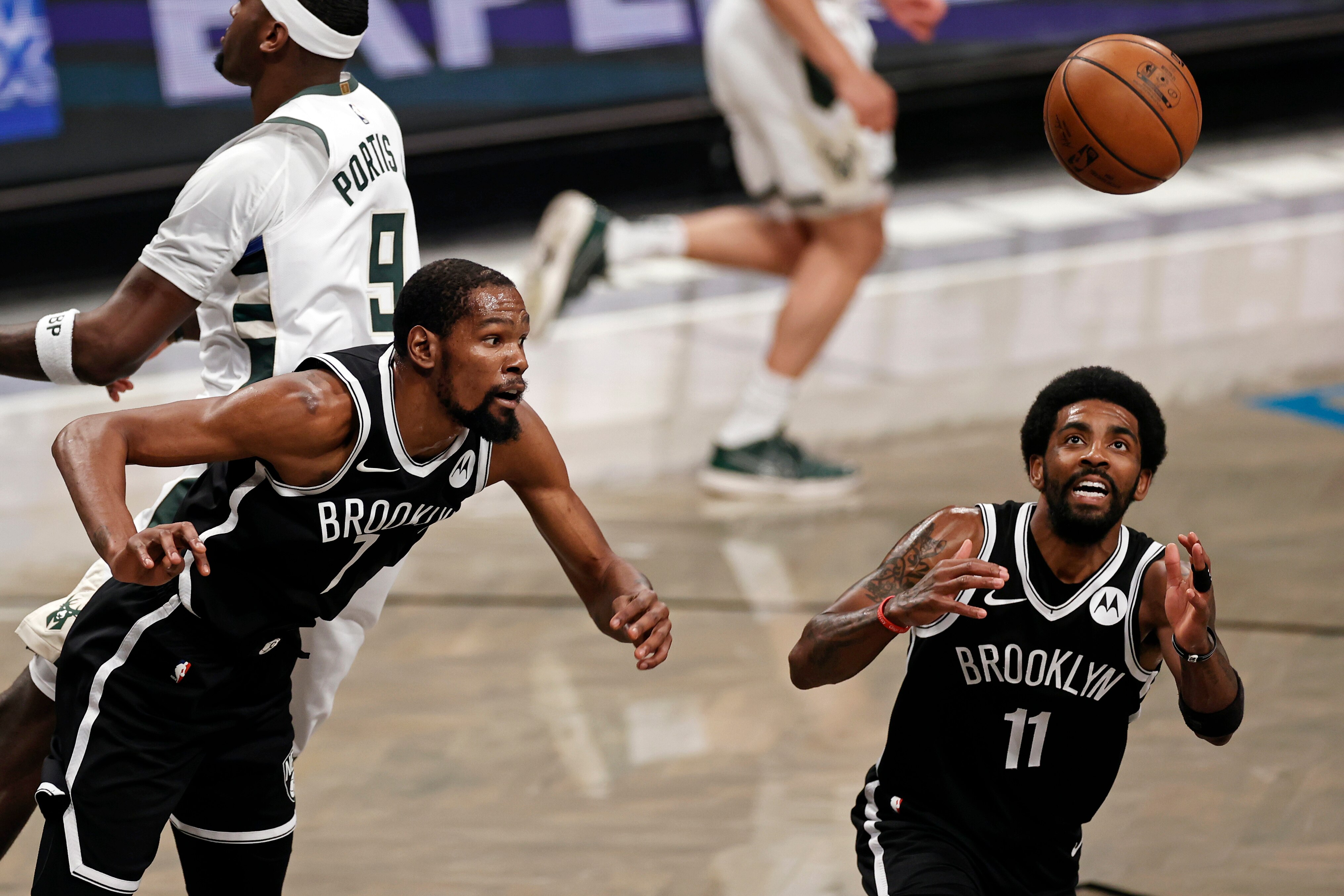 Brooklyn Nets forward Kevin Durant (7) and Kyrie Irving go for a rebound against the Milwaukee Bucks during the first half of Game 1 of an NBA basketball second-round playoff series Saturday, June 5, 2021, in New York. (AP Photo/Adam Hunger)