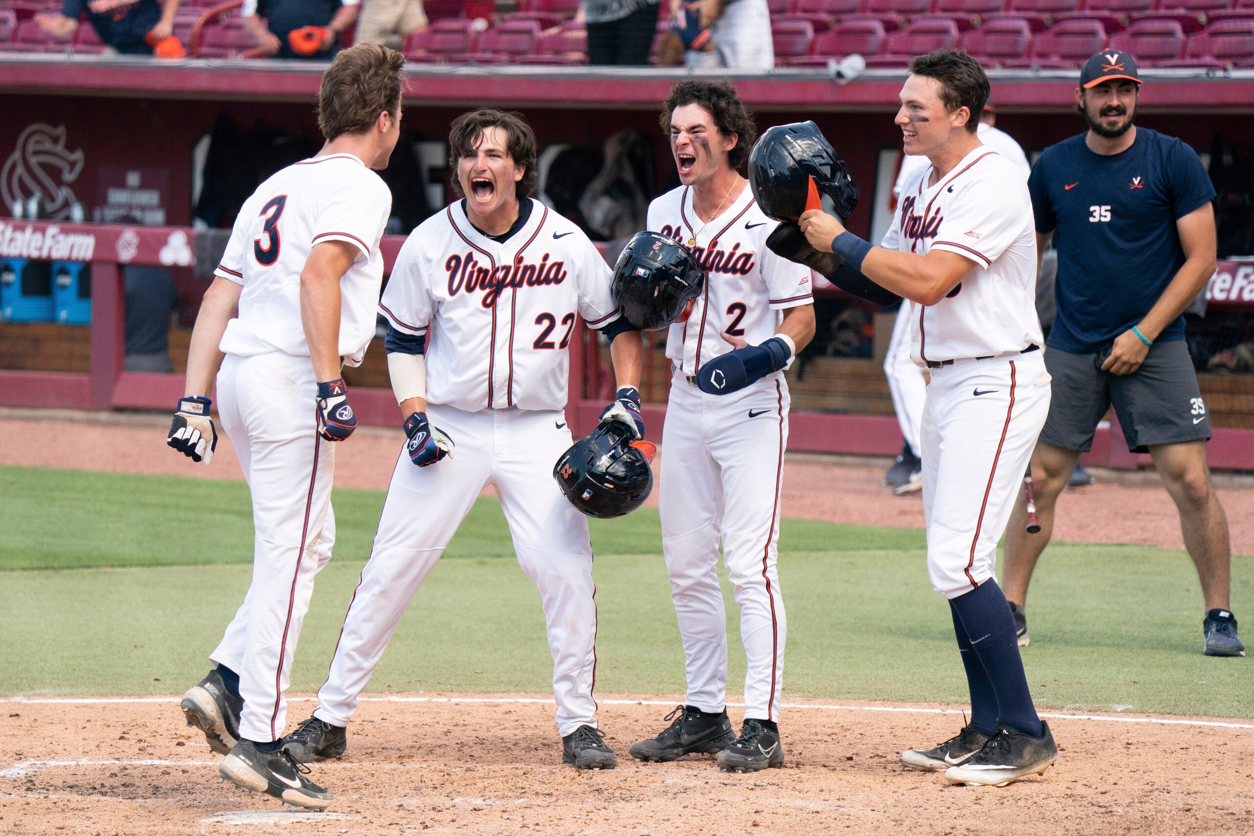 Virginia's Kyle Teel (3) steps on home plate after hitting a grand slam as Jake Gelof (22), Max Cotier (2), and Zack Gelof, front right, celebrate during an NCAA college baseball tournament super regional game against Dallas Baptist, Monday, June 14, 2021, in Columbia, S.C. (AP Photo/Sean Rayford)