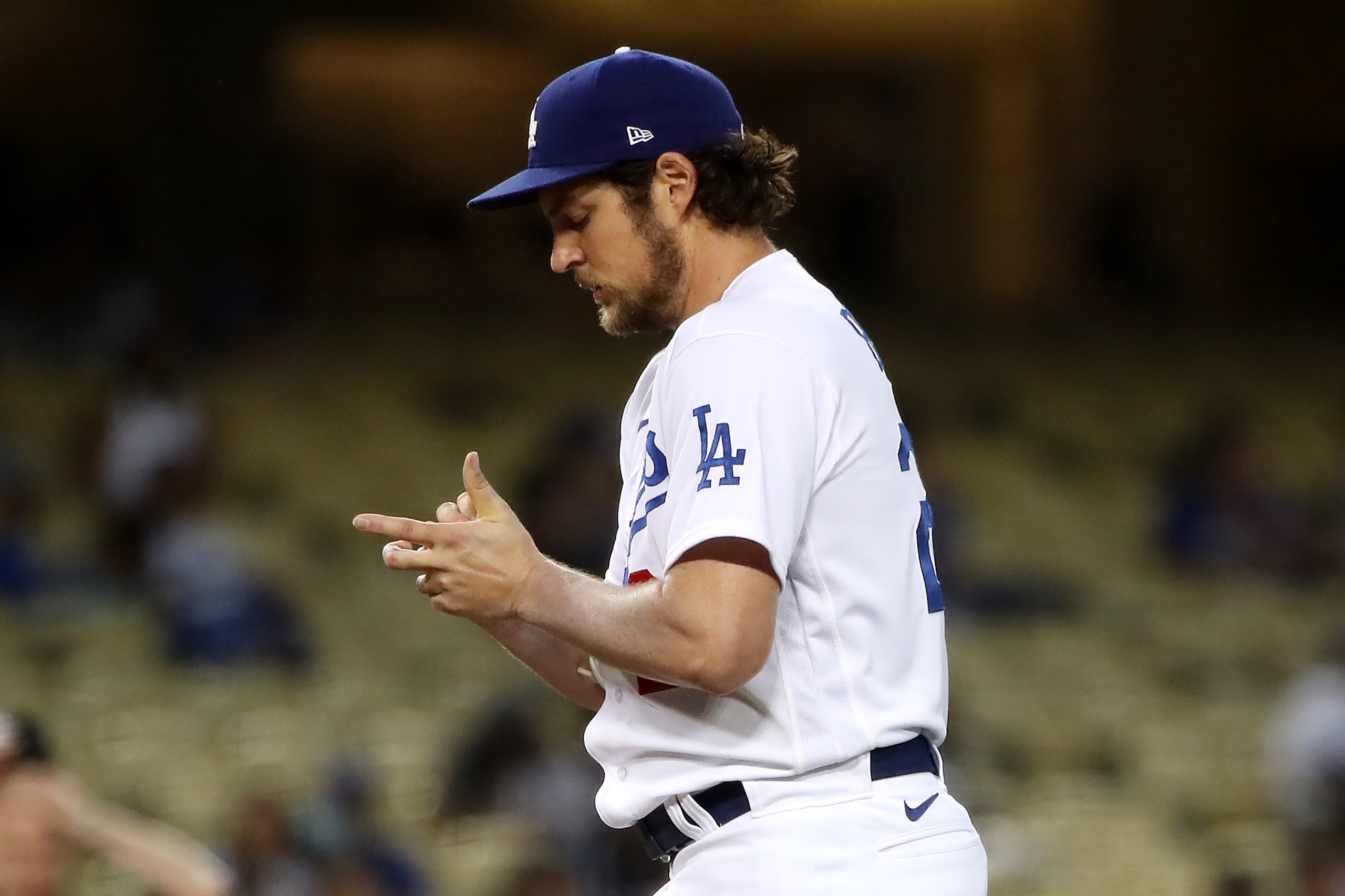 LOS ANGELES, CALIFORNIA - JUNE 12: Trevor Bauer #27 of the Los Angeles Dodgers looks down at the ball during the third inning against the Texas Rangers at Dodger Stadium on June 12, 2021 in Los Angeles, California. (Photo by Katelyn Mulcahy/Getty Images)