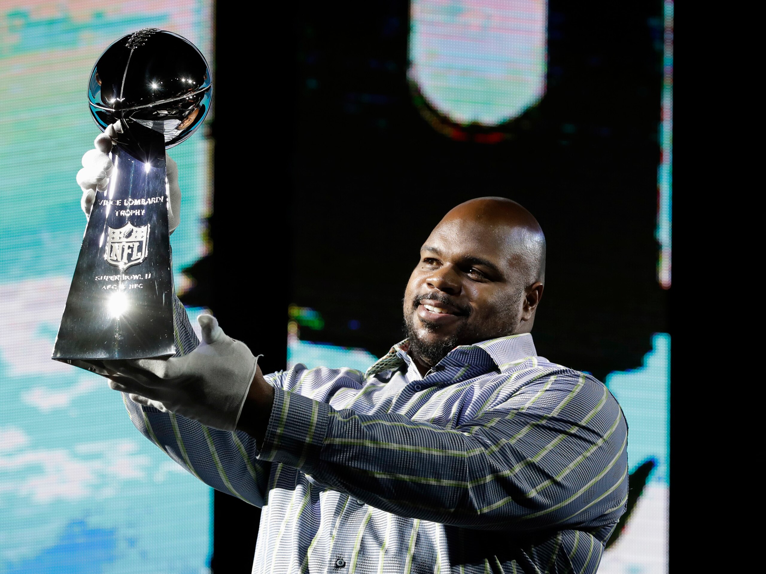 Houston Texans' Vince Wilfork holds up the Vince Lombardi Trophy as he helps with delivery of the trophy at the NFL Experience Saturday, Jan. 28, 2017, in Houston. The New England Patriots will play the Atlanta Falcons in Super Bowl LI Sunday, Feb. 5, 2017, at NRG Stadium in Houston. (AP Photo/David J. Phillip)