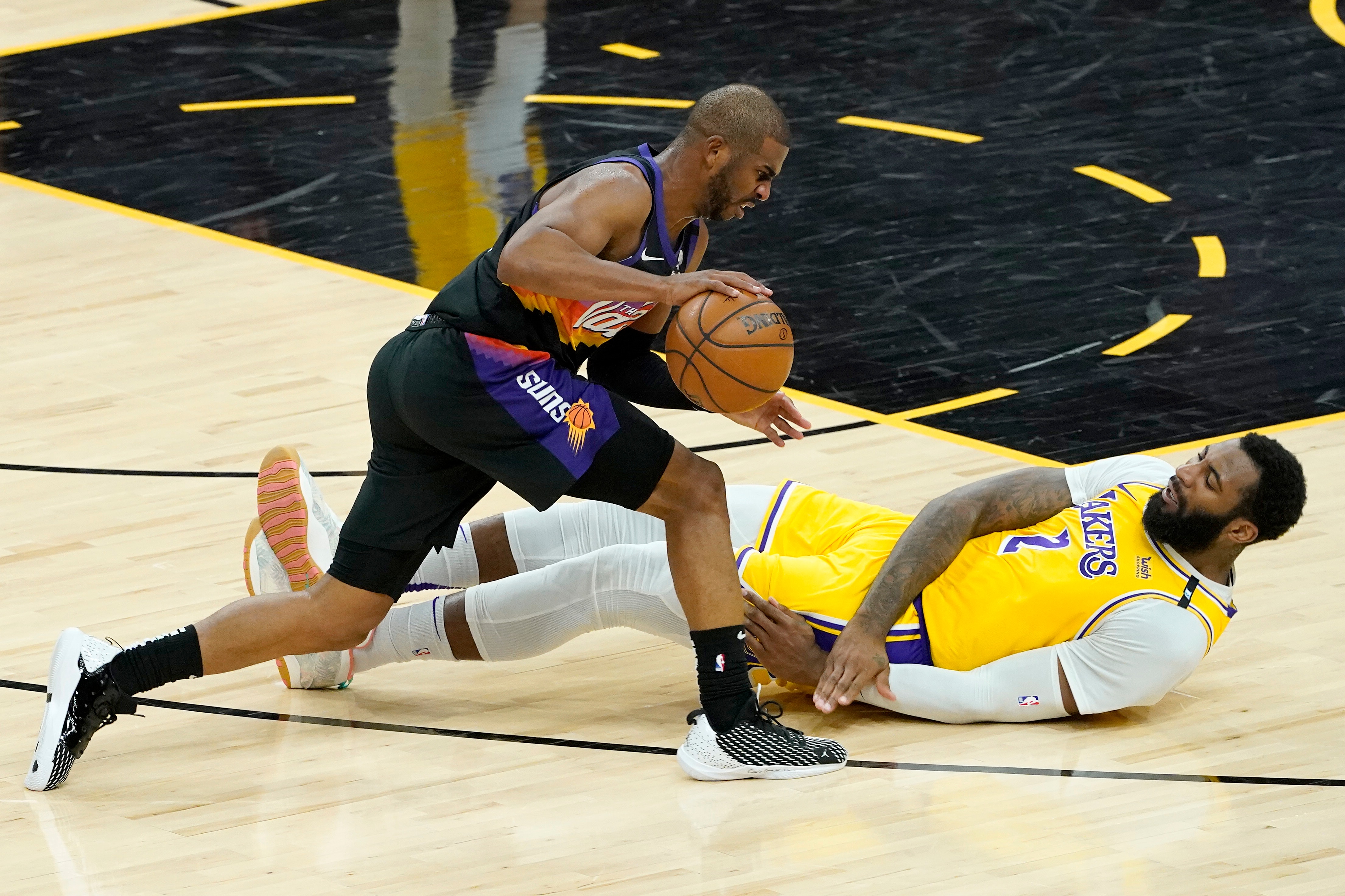 Los Angeles Lakers center Andre Drummond (2) falls as Phoenix Suns guard Chris Paul (3) drives during the first half of Game 5 of an NBA basketball first-round playoff series, Tuesday, June 1, 2021, in Phoenix. (AP Photo/Matt York)