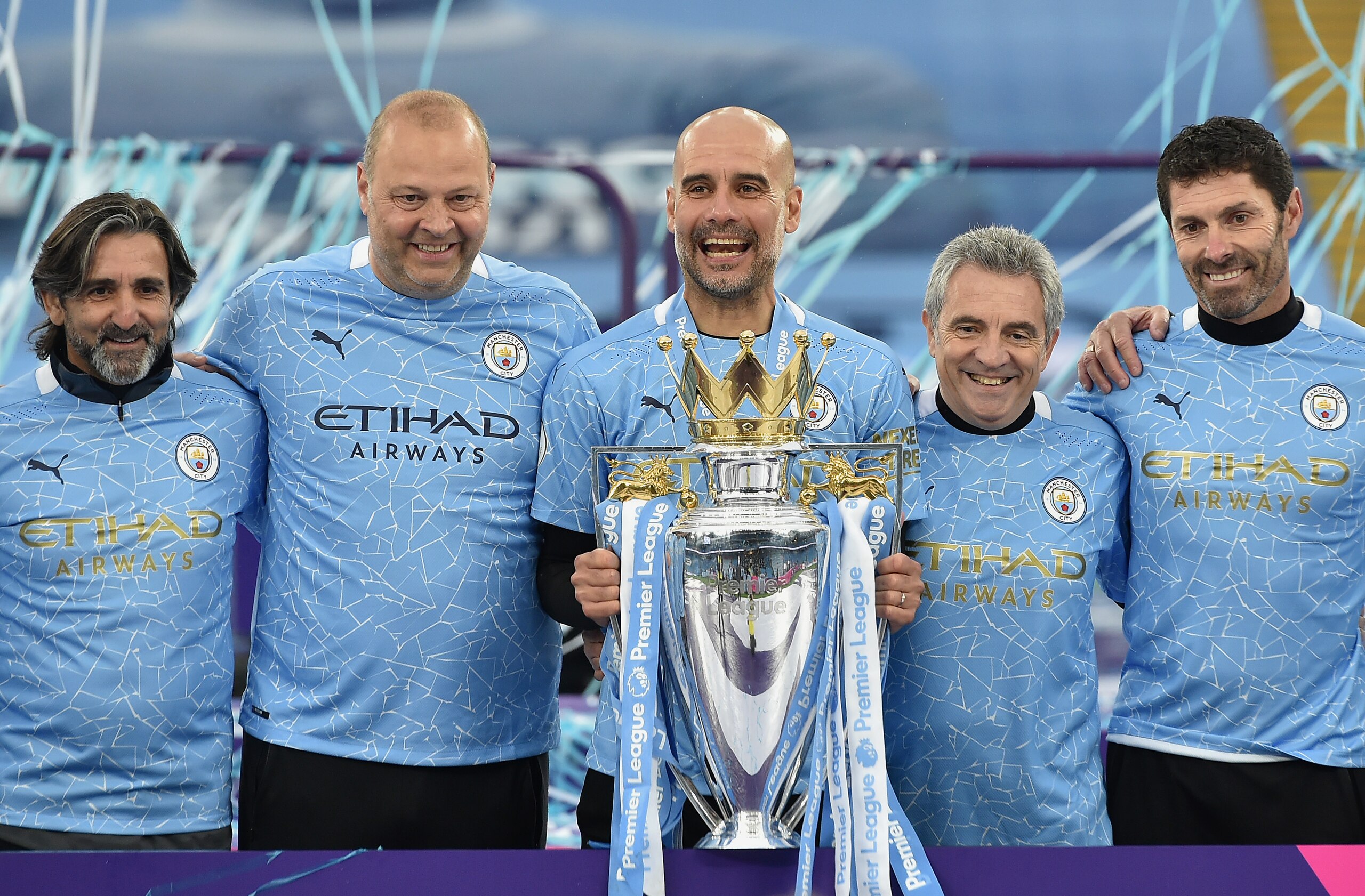 MANCHESTER, ENGLAND - MAY 23:  Lorenzo Buenaventura, Fitness Coach of Manchester City, Rodolfo Borrell, Assistant Coach of Manchester City, Pep Guardiola, Manager of Manchester City, Juanma Lillo, Assistant Manager of Manchester City, and Xabier Mancisidor, Goalkeeping Coach of Manchester City celebrate with the Premier League Trophy as Manchester City are presented with the Trophy as they win the league following the Premier League match between Manchester City and Everton at Etihad Stadium on May 23, 2021 in Manchester, England. A limited number of fans will be allowed into Premier League stadiums as Coronavirus restrictions begin to ease in the UK. (Photo by Peter Powell - Pool/Getty Images)