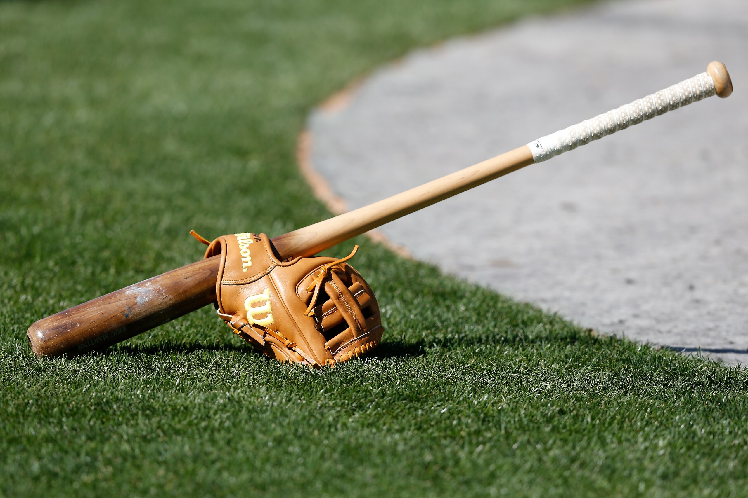 OAKLAND, CALIFORNIA - JUNE 08: A bat and glove sit on the field during batting practice before the game between the Oakland Athletics and the Arizona Diamondbacks at RingCentral Coliseum on June 08, 2021 in Oakland, California. (Photo by Lachlan Cunningham/Getty Images) OAKLAND, CALIFORNIA - JUNE 08: A bat and glove sit on the field during batting practice before the game between the Oakland Athletics and the Arizona Diamondbacks at RingCentral Coliseum on June 08, 2021 in Oakland, California. (Photo by Lachlan Cunningham/Getty Images)